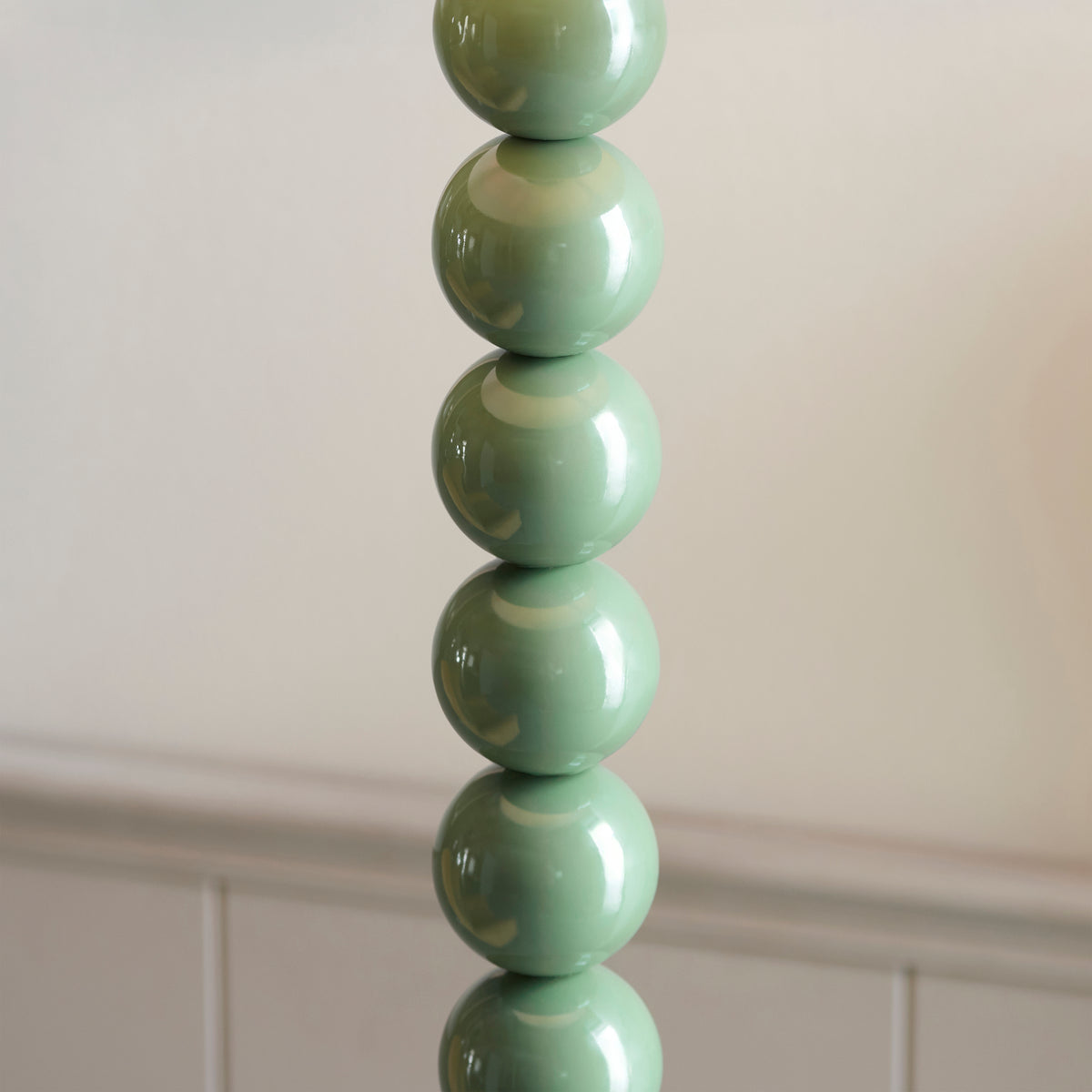 Detail of the stacked gloss Cotswold green steel spheres on the Endon Higgledy floor lamp stem, showing the high shine finish