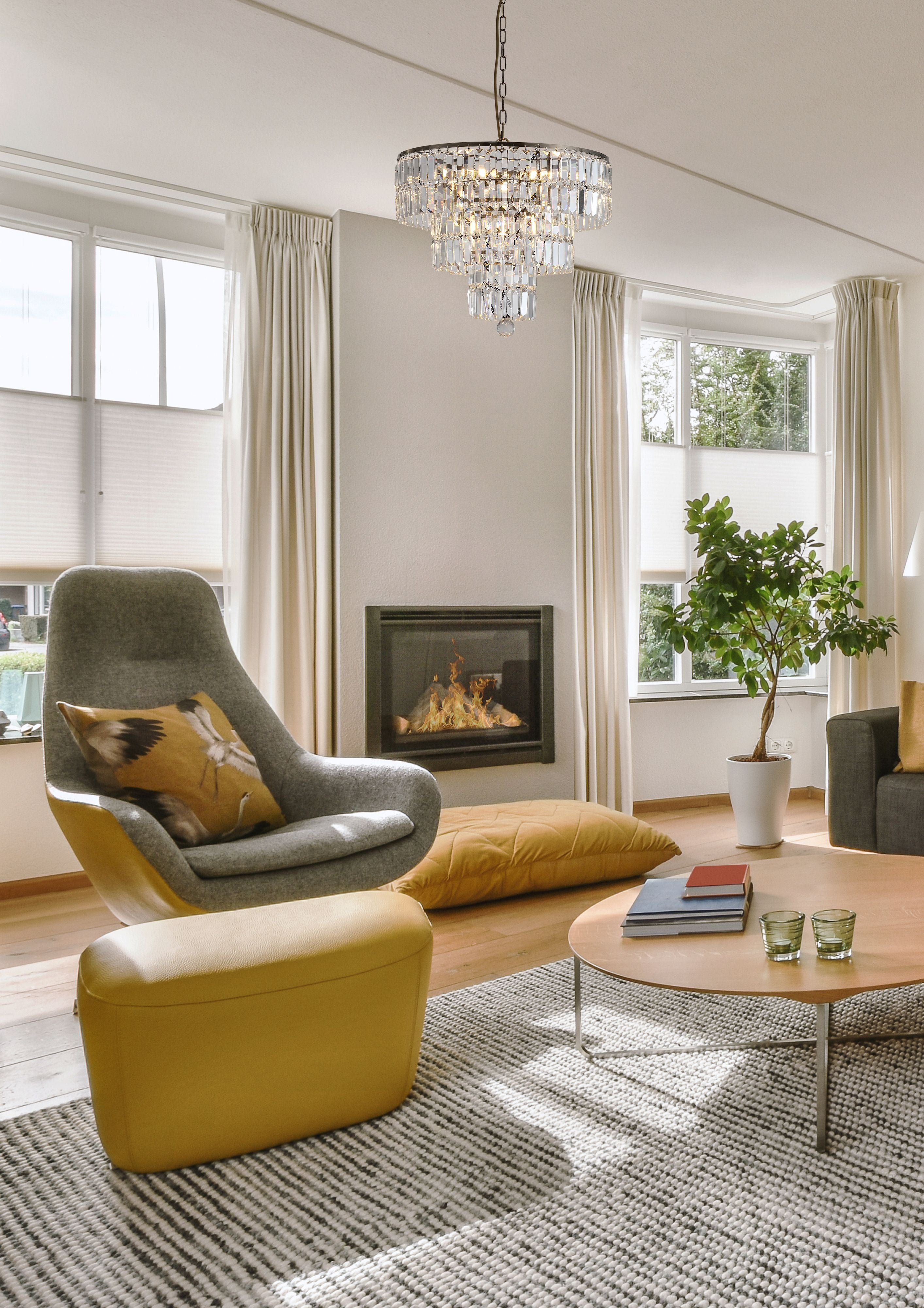 Empire 5 Light Pendant lit and hanging in a bright living room with a fireplace
