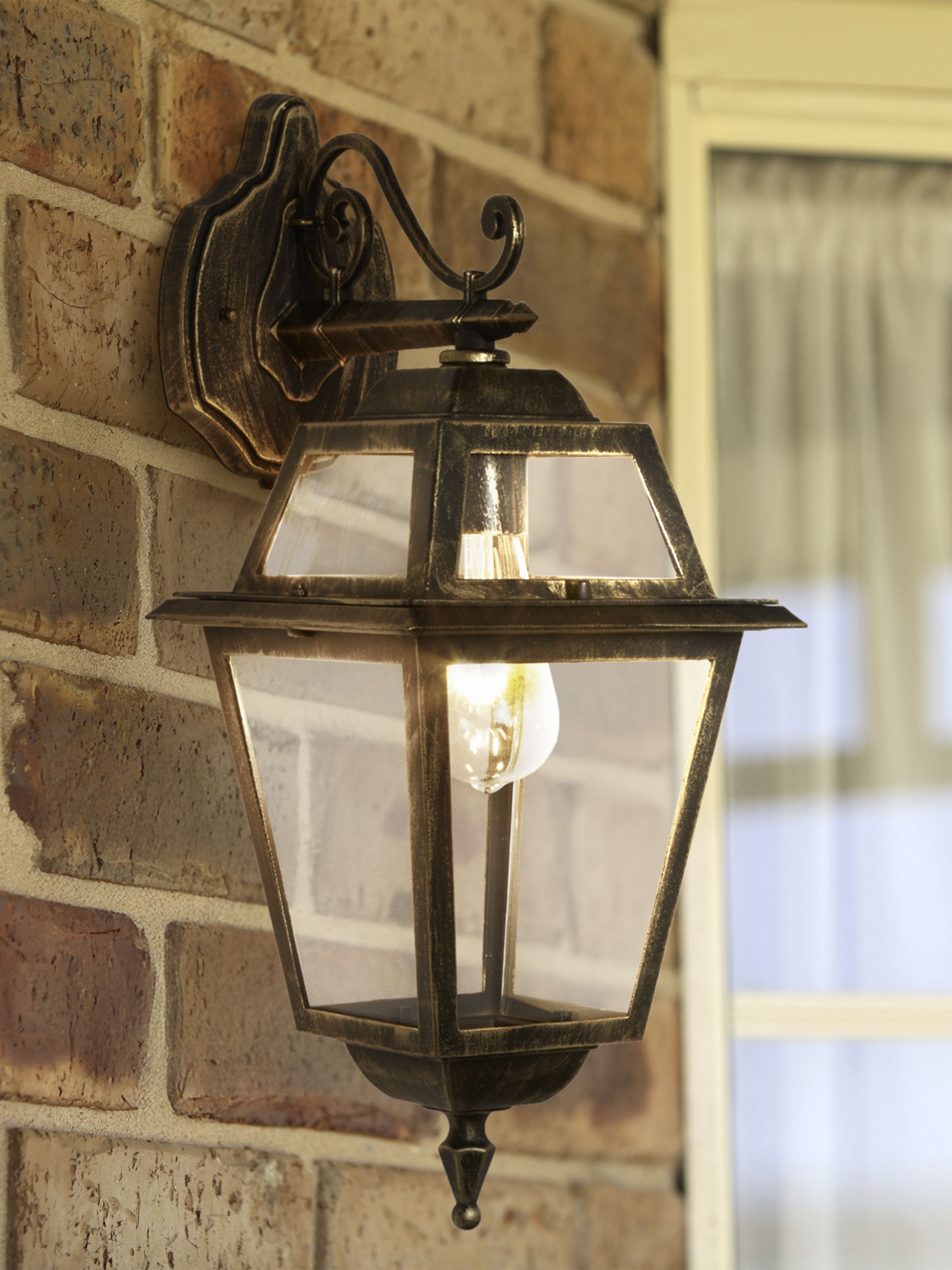New Orleans outdoor downlight installed and lit on a brick wall beside a window