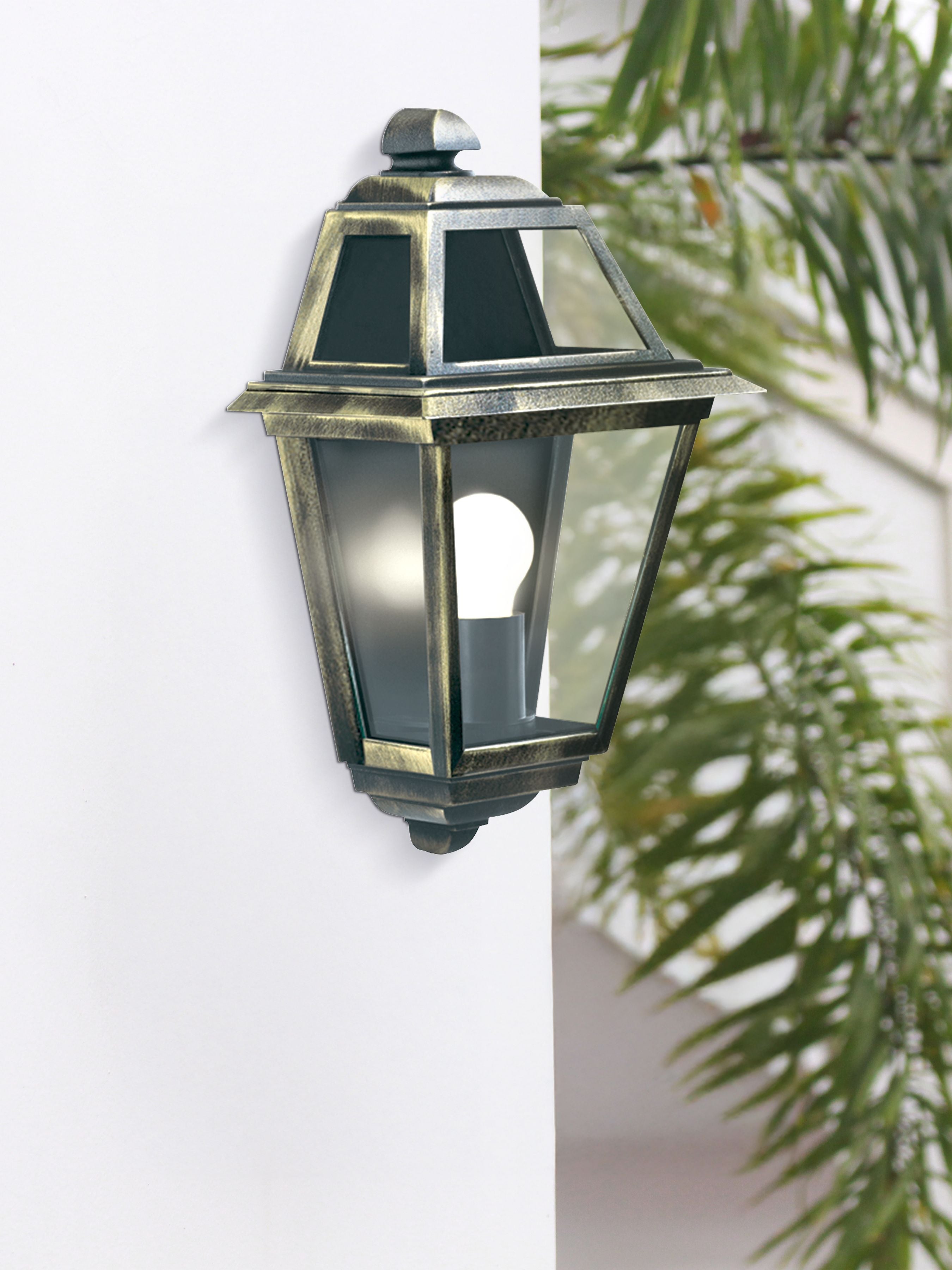New Orleans flush outdoor wall light installed and lit on an exterior wall beside a plant