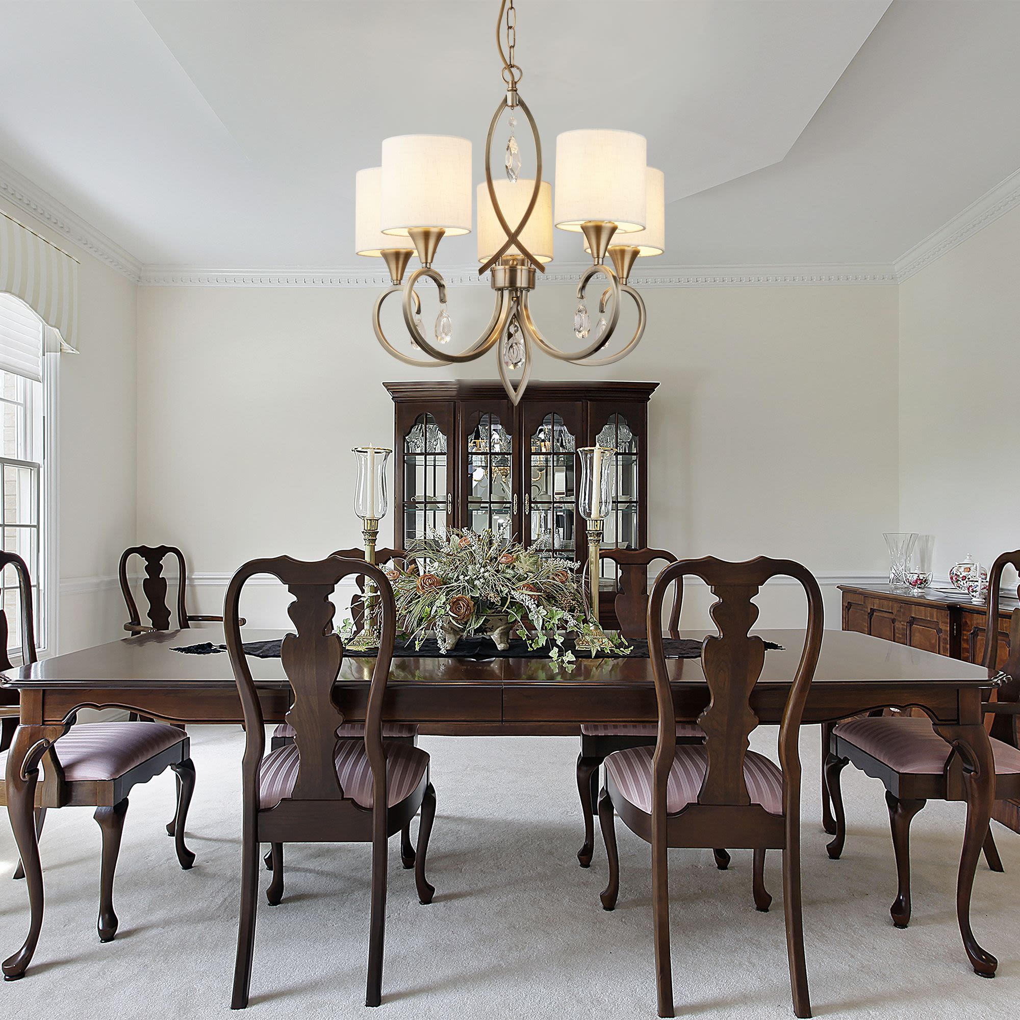 Searchlight Alberto 5 Light Pendant in antique brass styled above a dark wood dining table set for a formal dining room