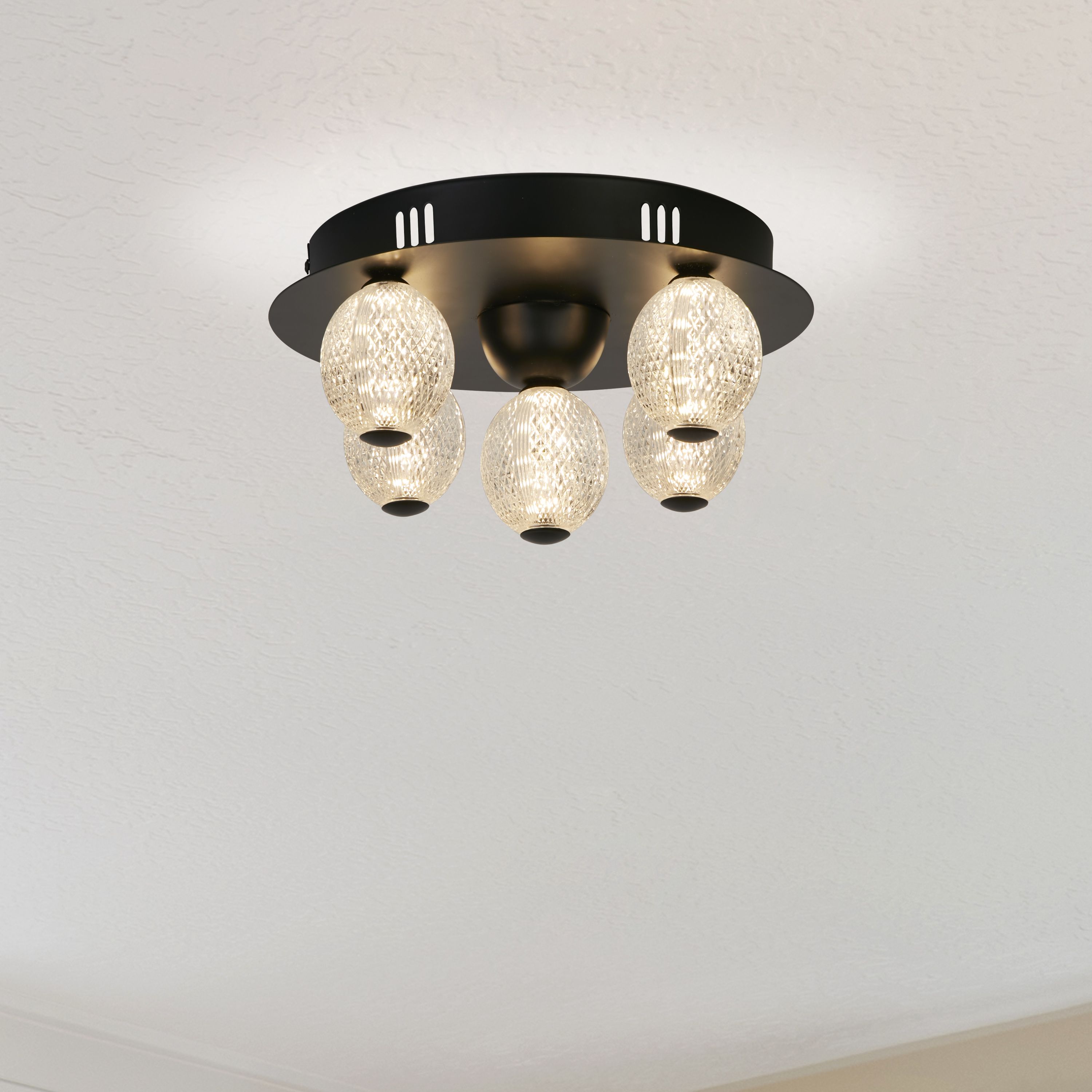 Asteroid LED flush ceiling light fitted to a plain ceiling in a studio setting, showing the black backplate and glowing spheres