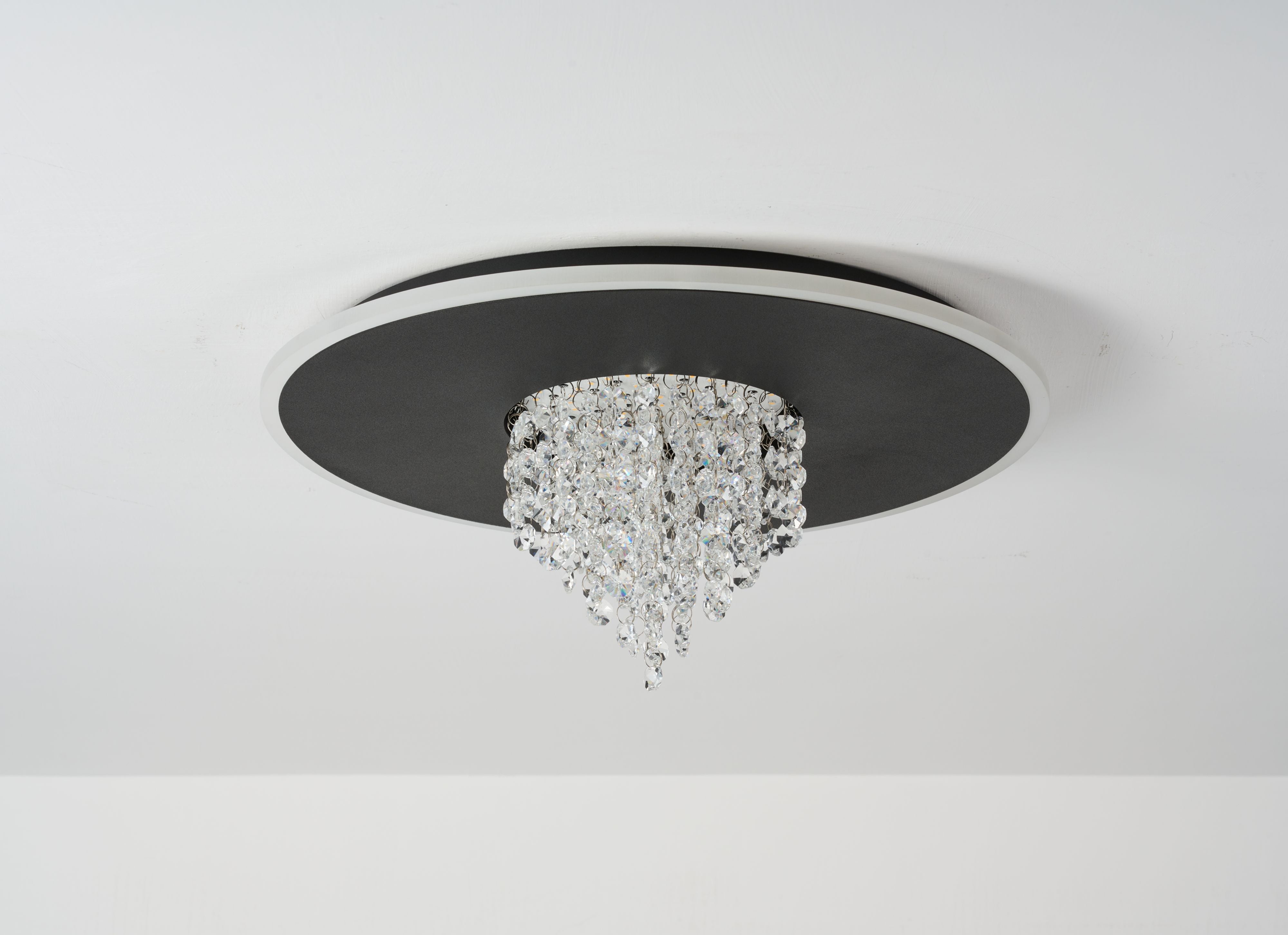 Searchlight Deluge LED flush ceiling light in black mounted on a white ceiling, three quarter view showing the crystal drops catching the light