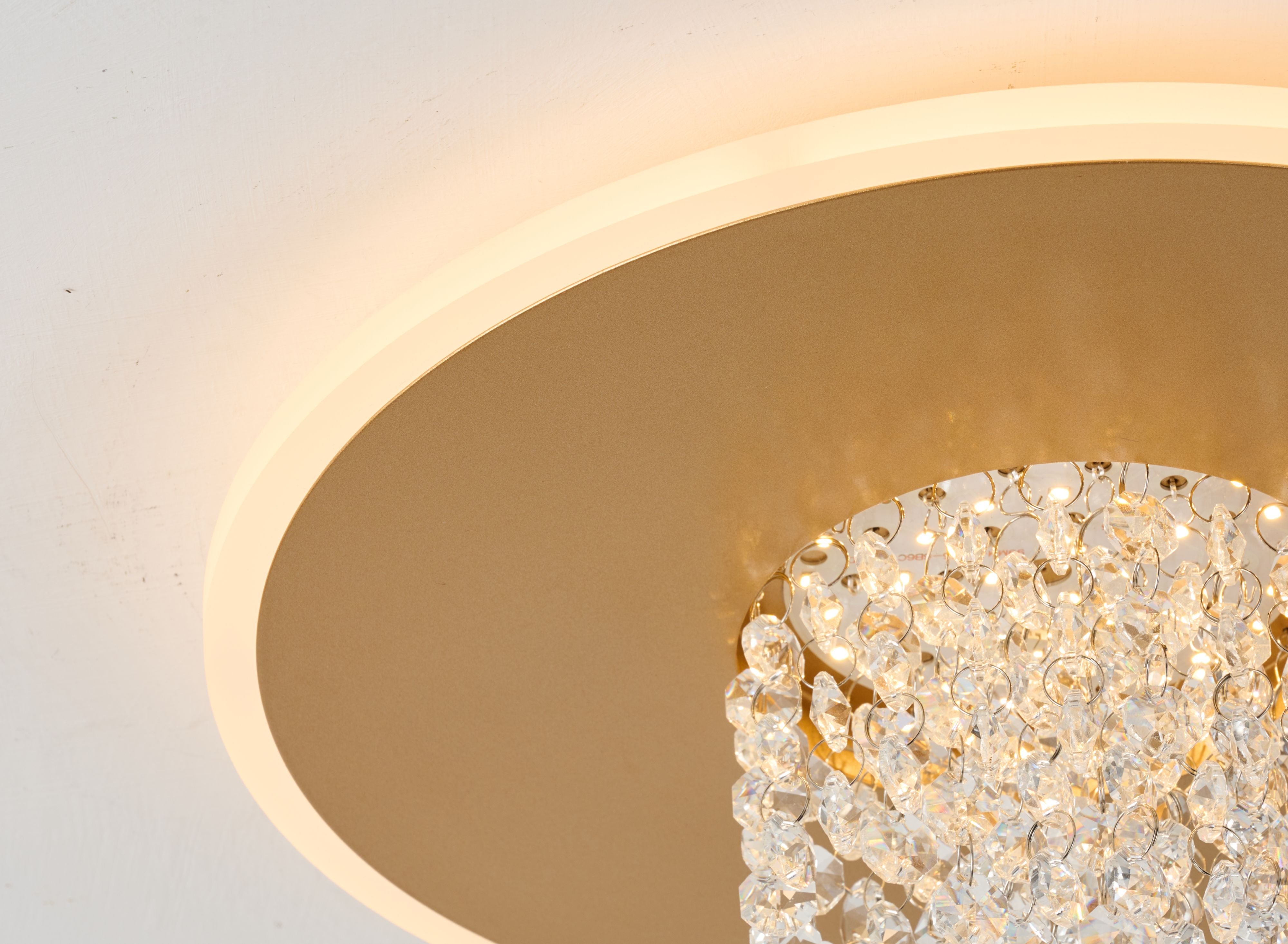Close up underneath the Searchlight Deluge LED flush ceiling light in gold, showing the crystal cascade and LED points of light inside the gold plate
