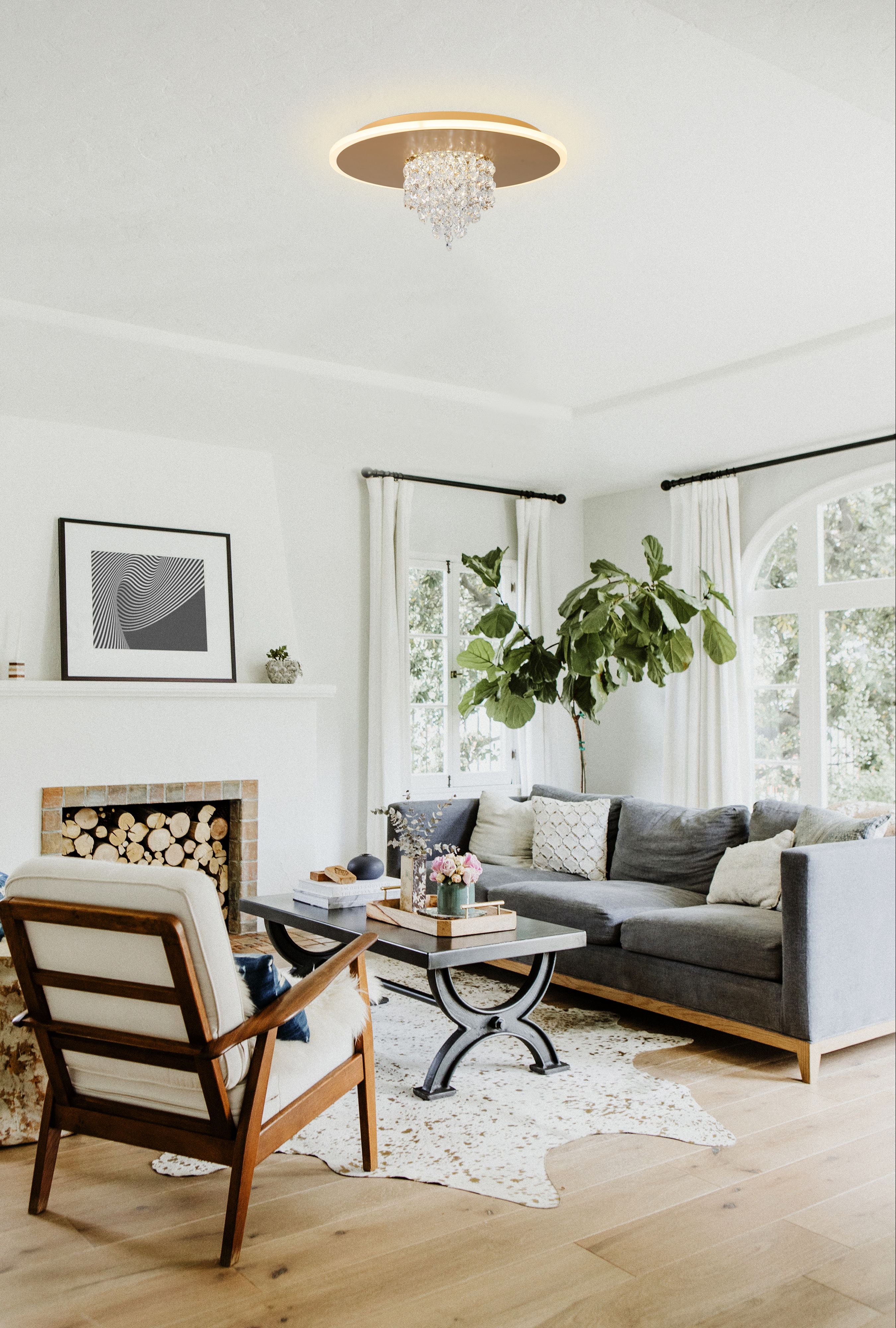Searchlight Deluge LED flush ceiling light in gold installed in a bright living room with grey sofas and a large potted plant