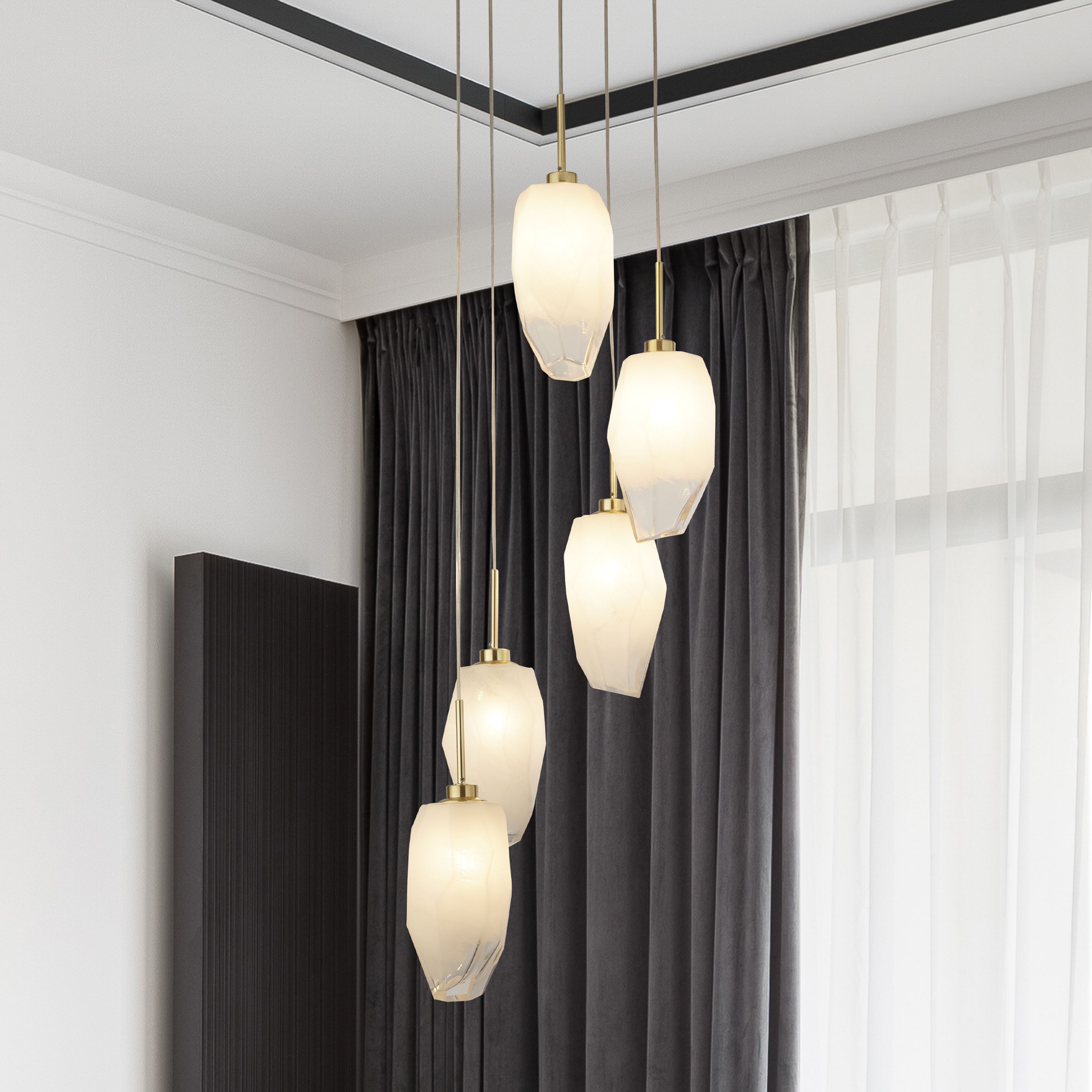 Rocky 5 light multi drop pendant hung in a room with dark grey curtains, five faceted shades staggered at different heights