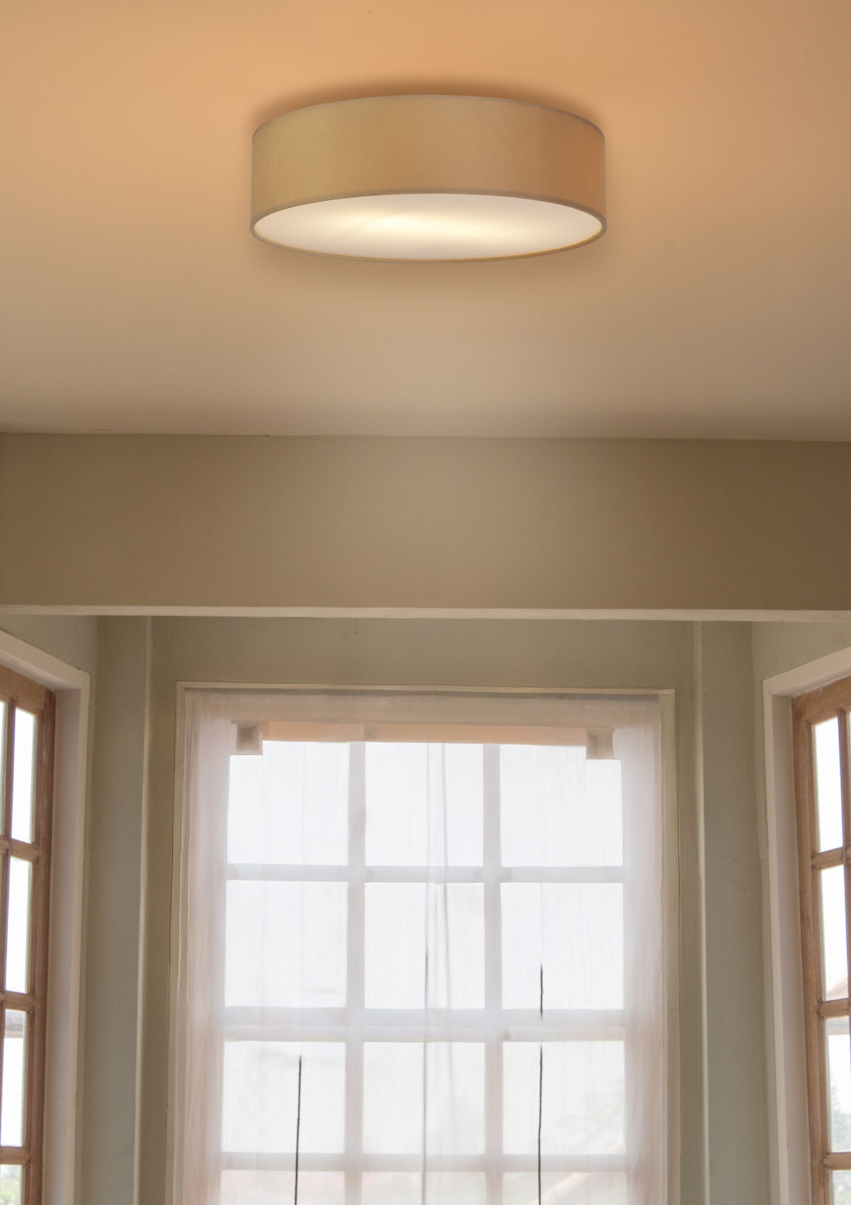 Searchlight Drum 2 light flush ceiling light in champagne velvet fitted to a ceiling above a bright bay window