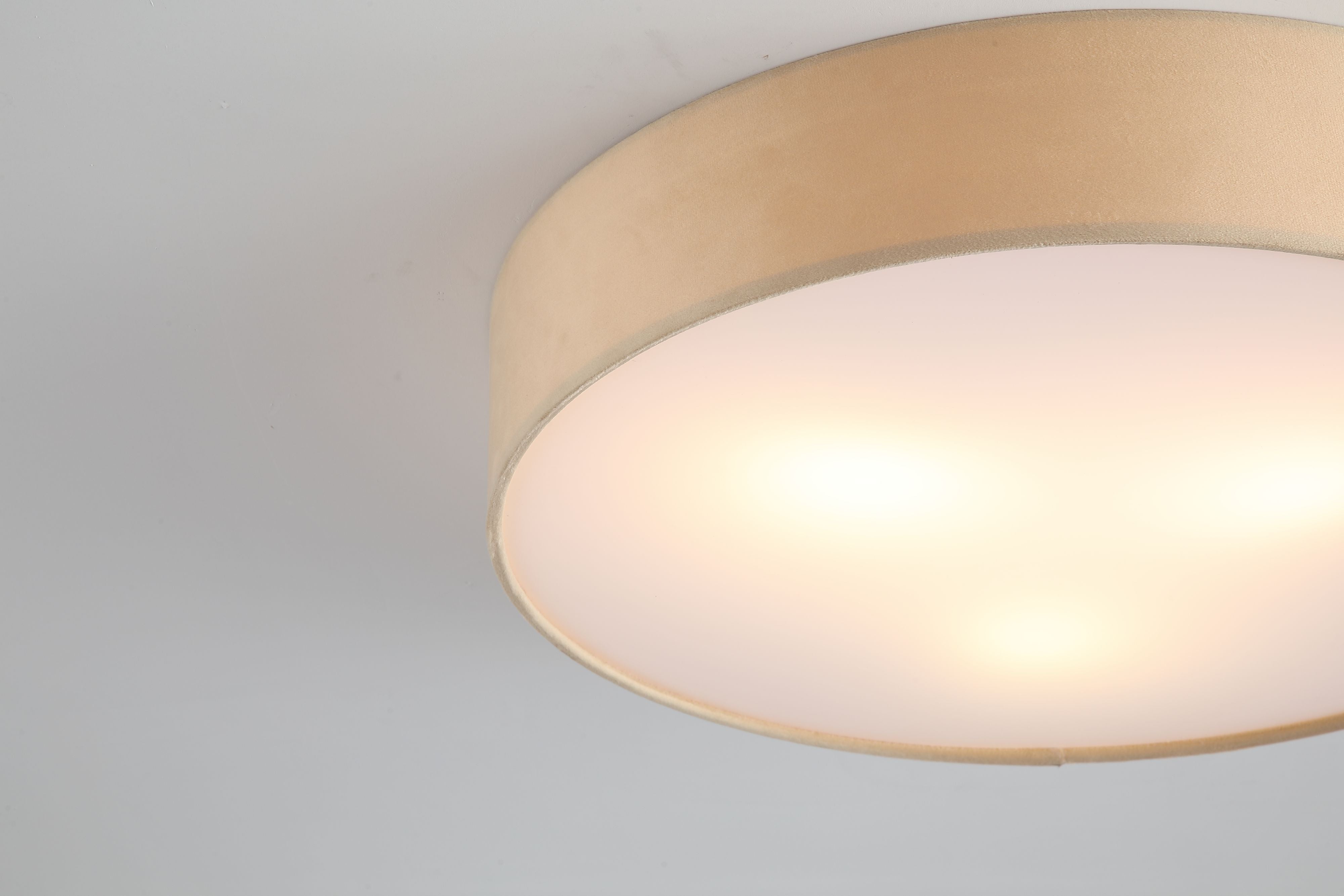 Close up of the champagne velvet fabric and frosted diffuser edge on the Searchlight Drum 3 light flush ceiling light