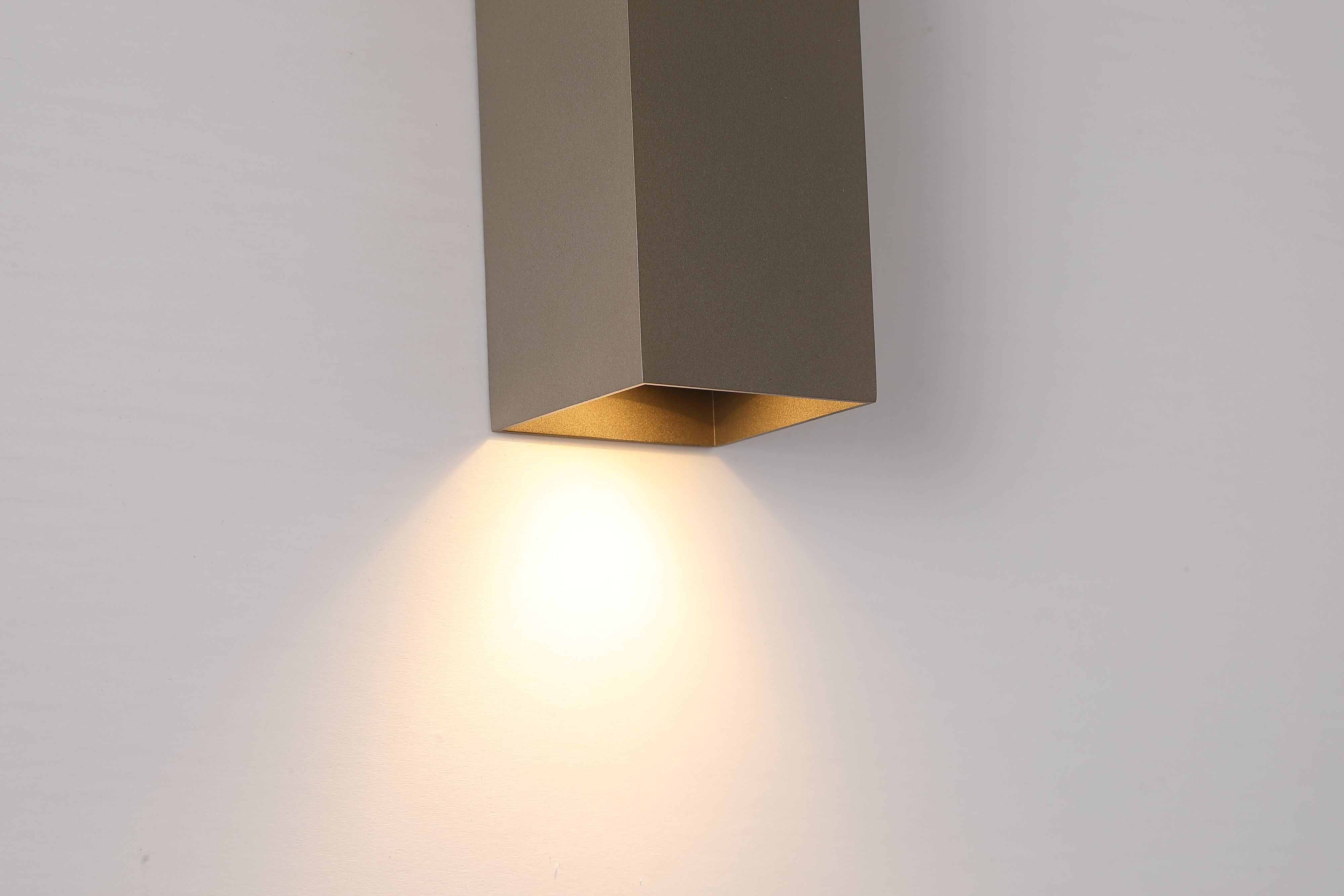 Close up of the Searchlight Don wall light in latte showing the warm gold toned interior of the bottom light channel