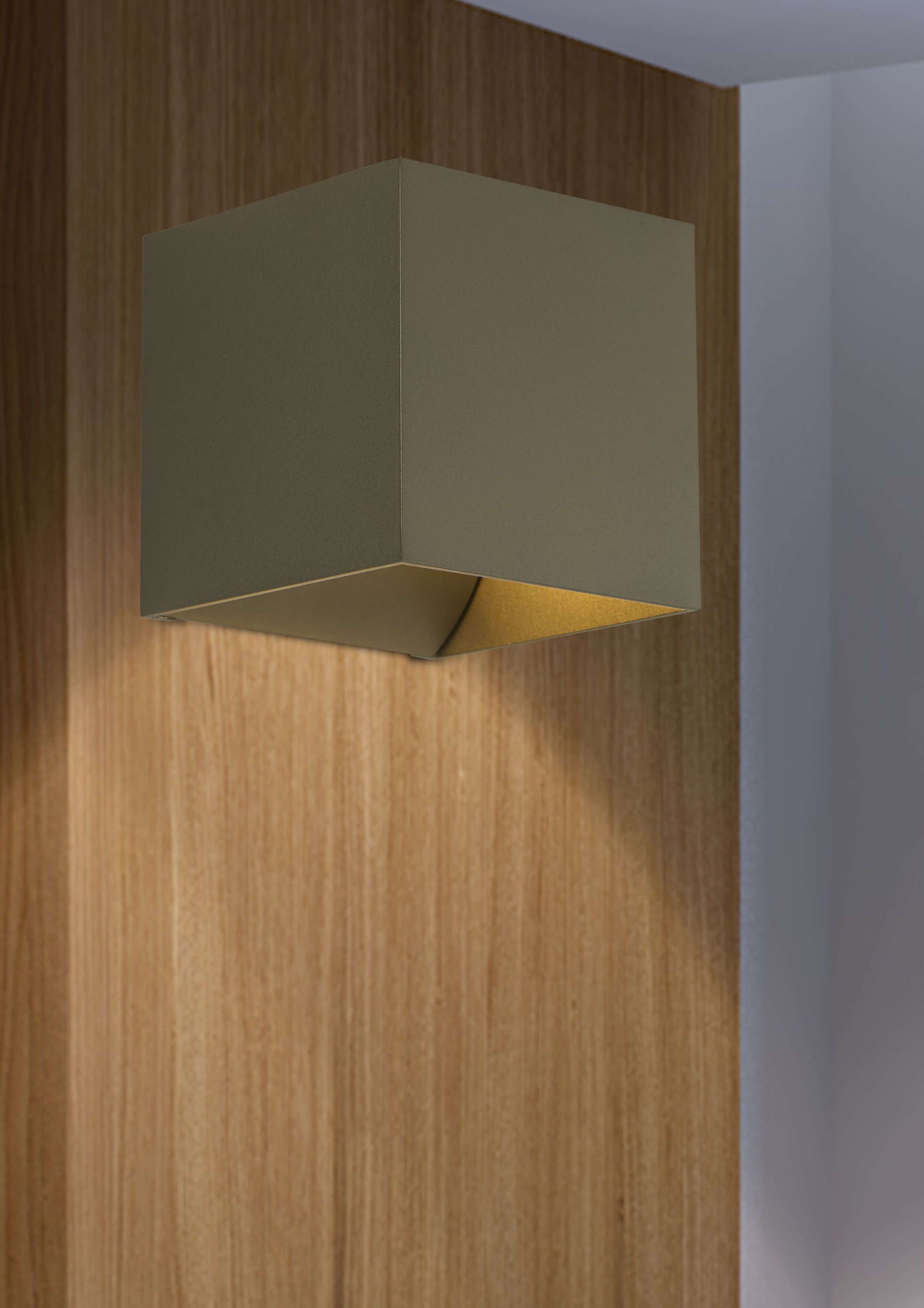 Newton Square Up & Down Wall Light in latte installed on a wood panelled wall, glowing with warm light above and below the fitting