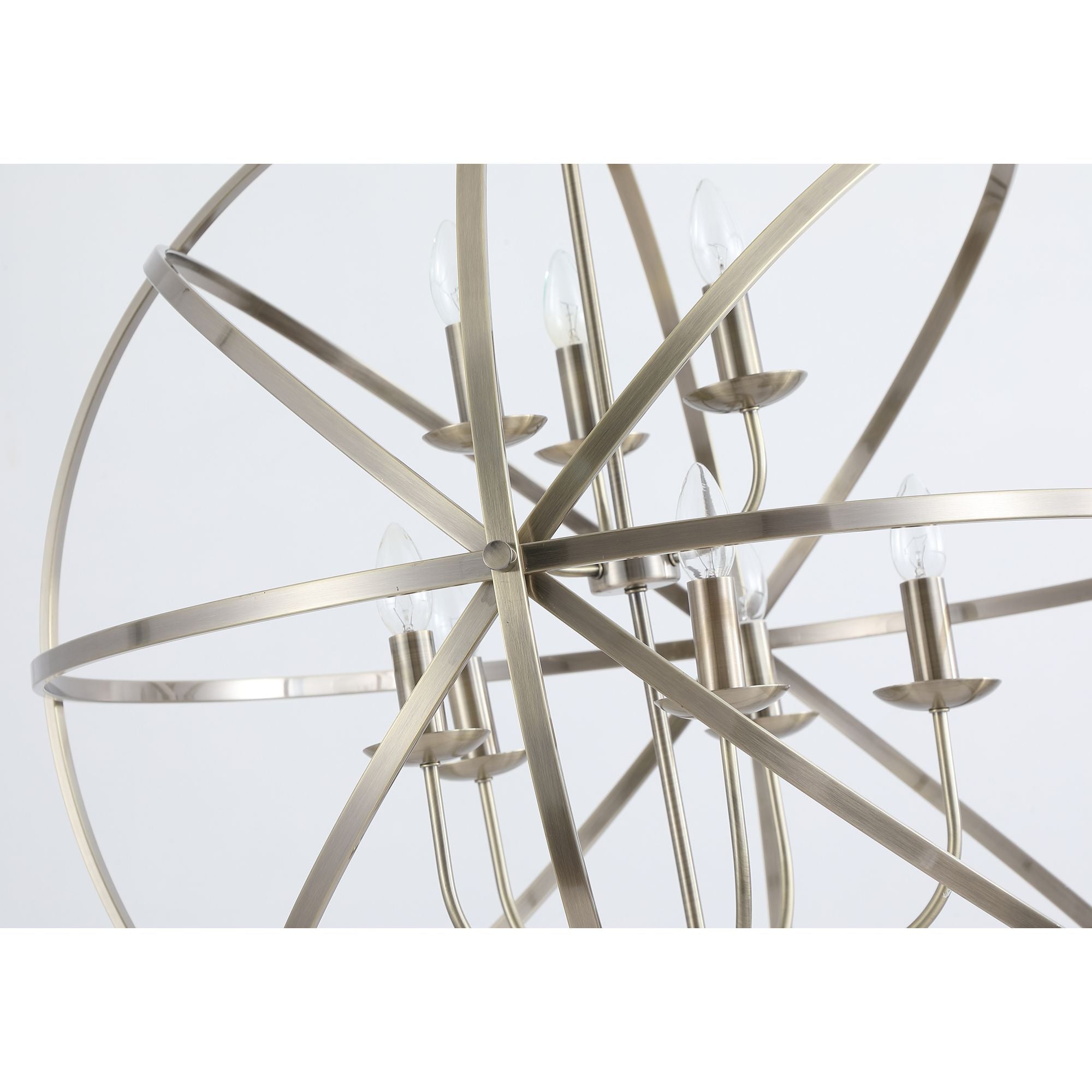 Close up of the Orbit pendant's antique brass frame showing the candle style bulb holders and crossing metal rings