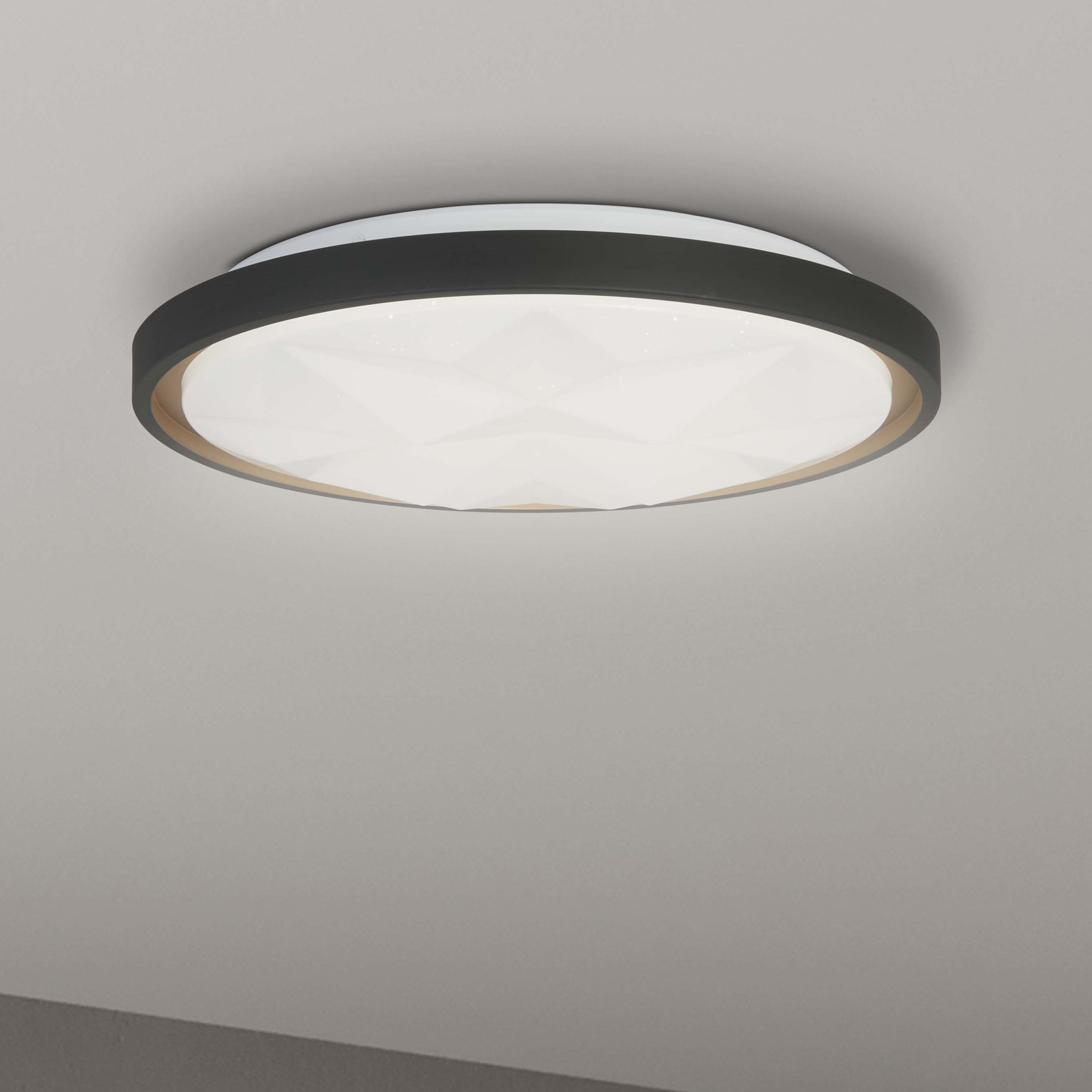 Searchlight Satellite LED flush ceiling light installed on a grey ceiling, lit