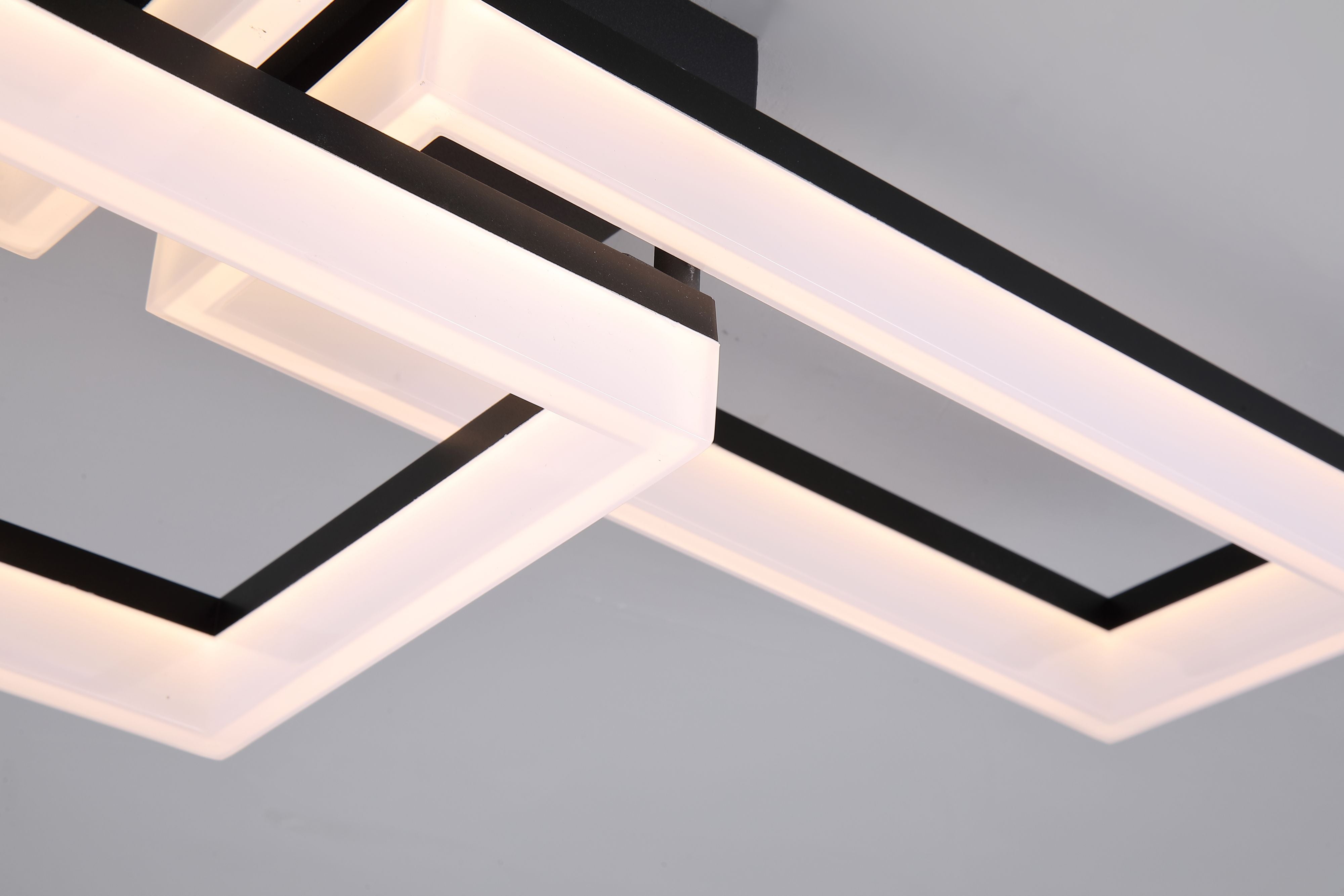 Close up of Wall Art II's matt black frame and white acrylic edge lighting where the two offset squares overlap