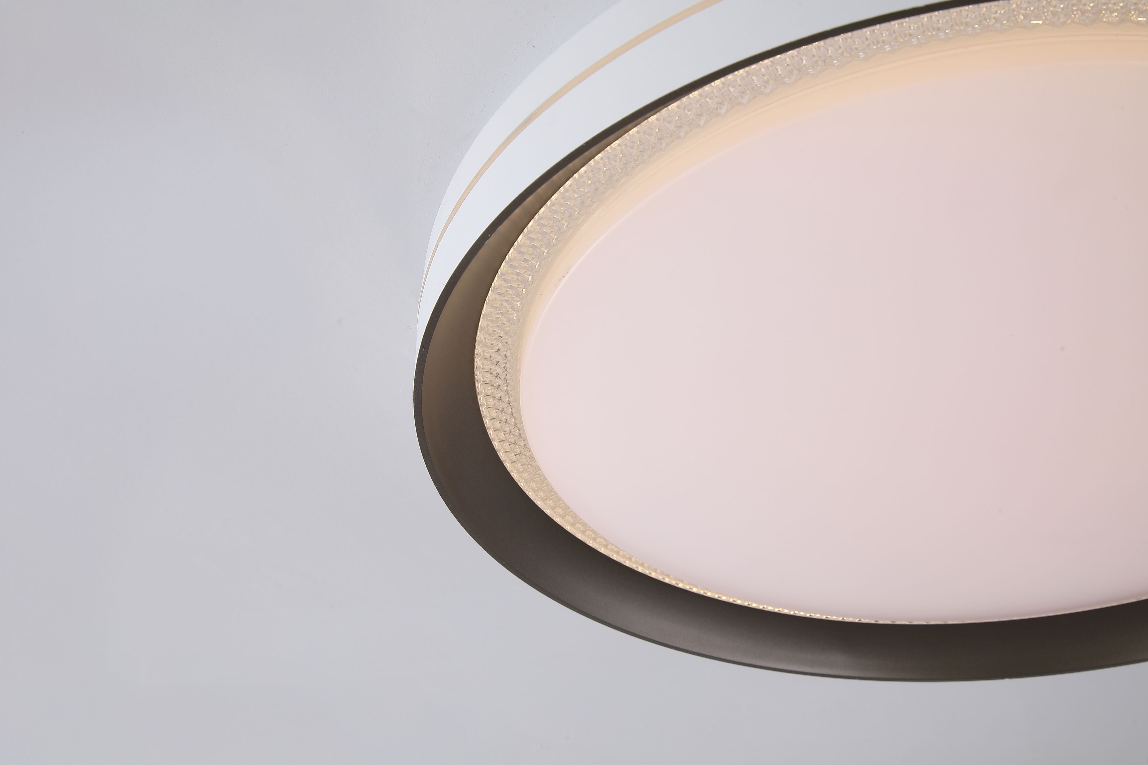 Close up of the Searchlight Saucer LED flush light showing the latte metal inner ring against the opal diffuser and white ceiling