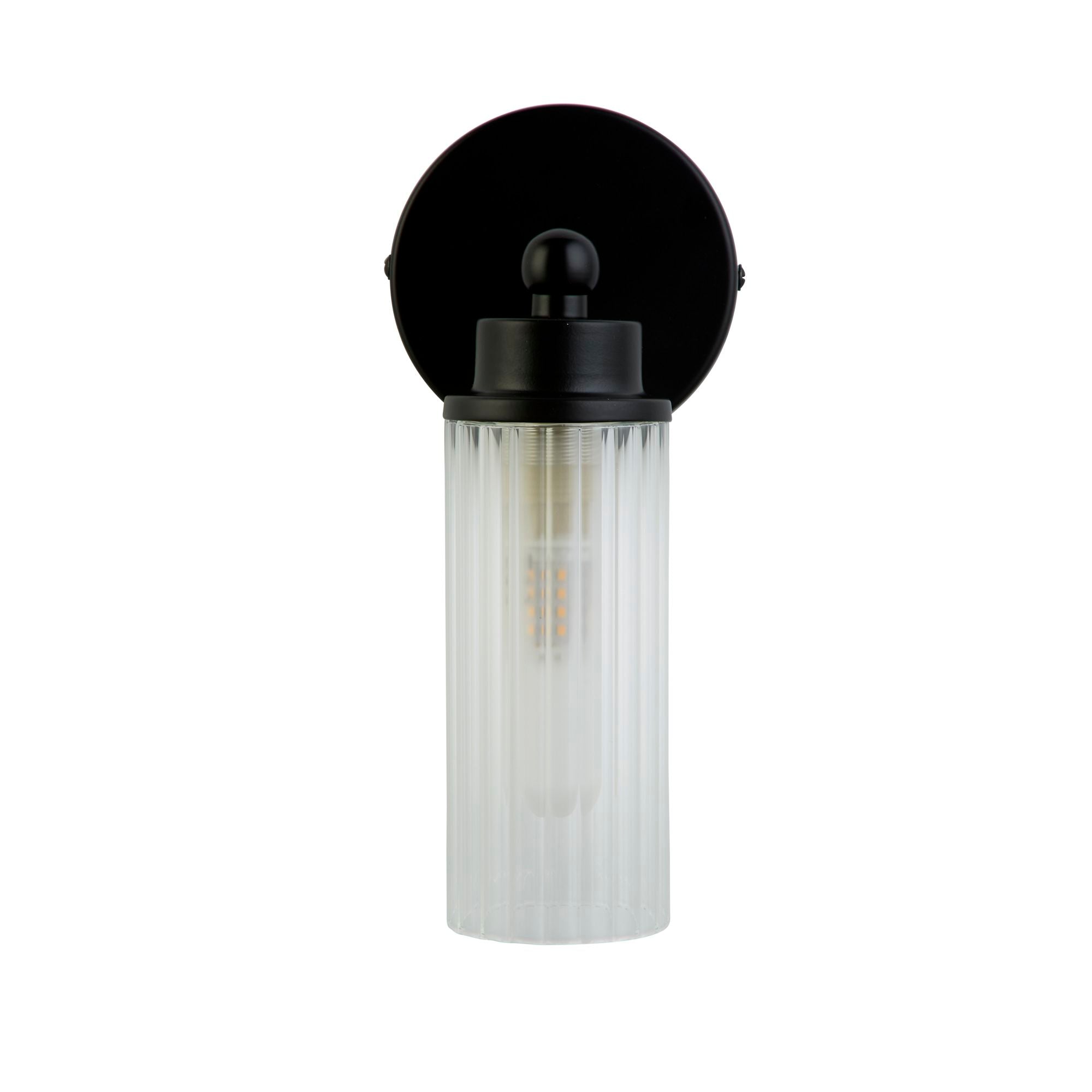 Searchlight Imperial 1 light wall light in matt black with clear ribbed glass shade, lit, front studio shot
