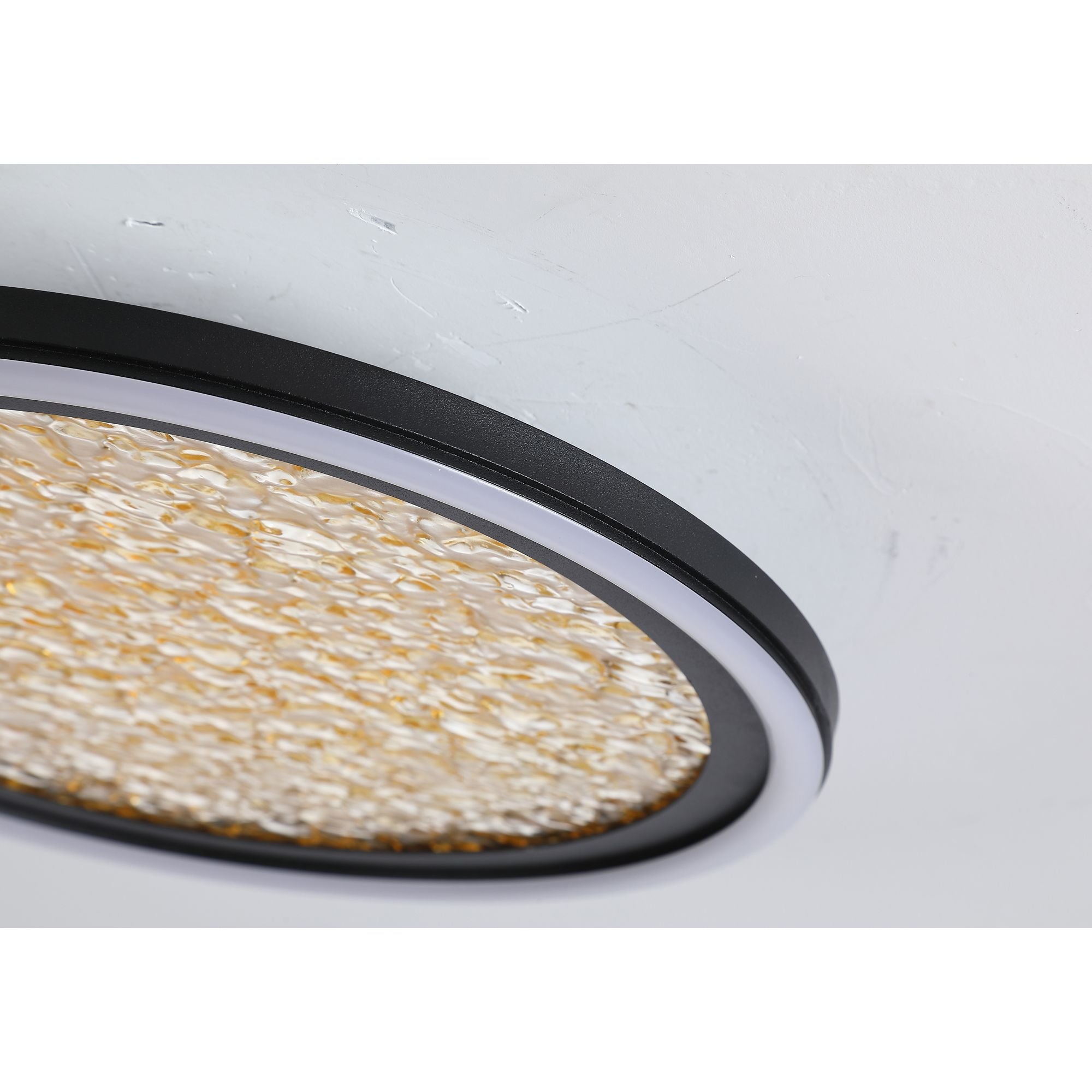 Close up of the Luna flush light's black rim and textured gold polycarbonate diffuser