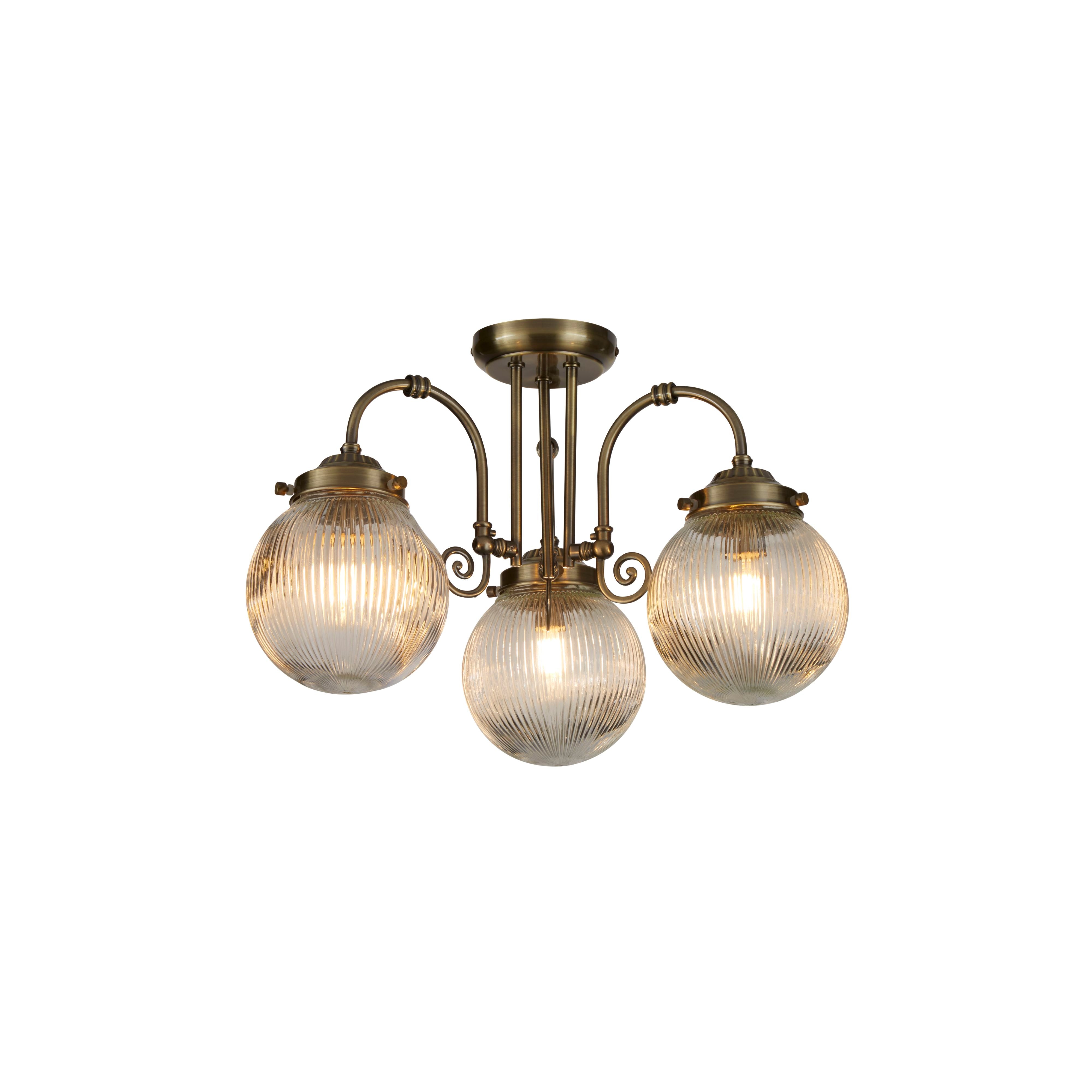 Searchlight Belvue 3 light flush ceiling light in antique brass, studio shot of three ribbed glass globes lit warm white on curved arms