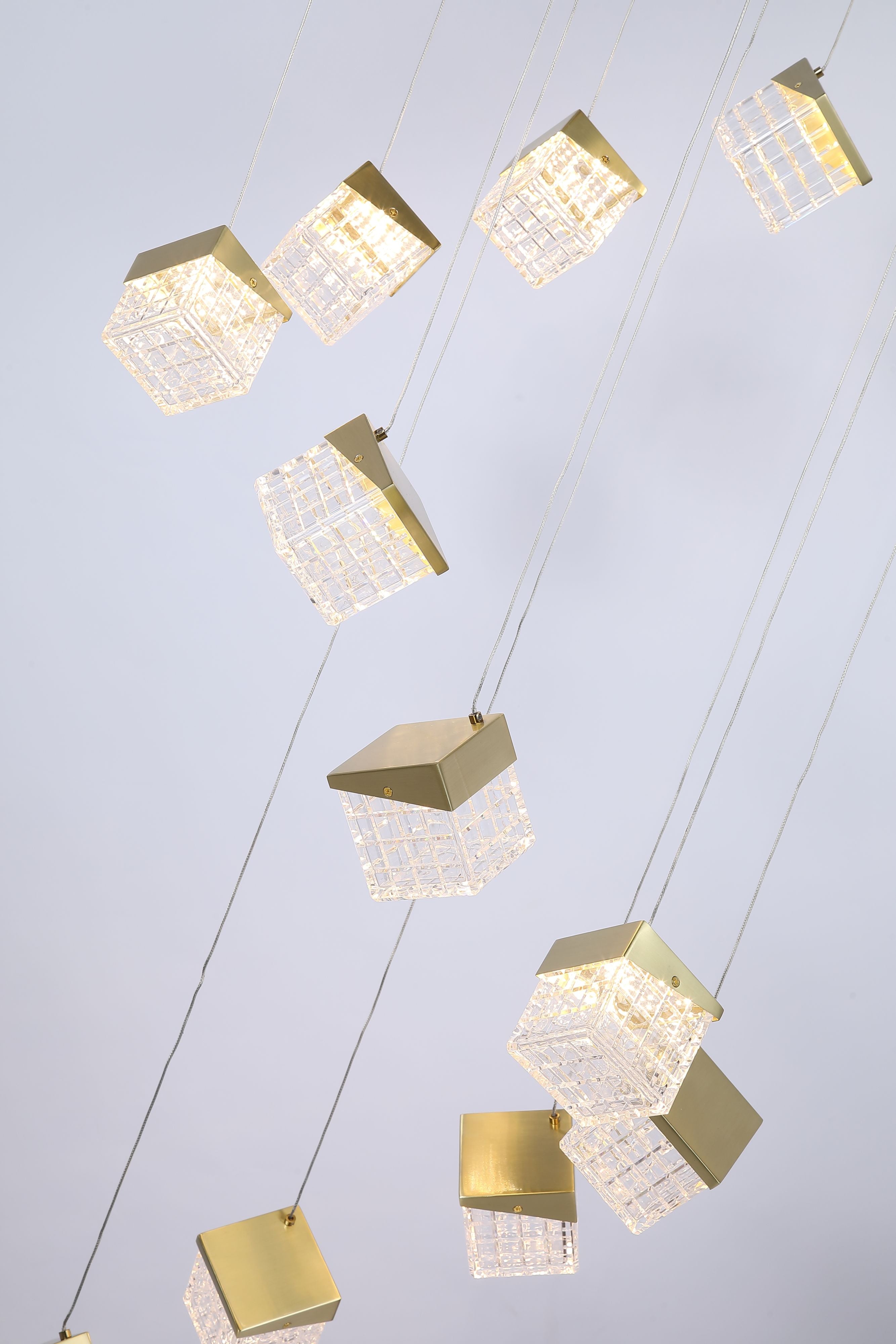 Close up of the faceted acrylic cubes and angled brass caps on the Cuboid 20 Light LED Multi Drop Pendant, lit