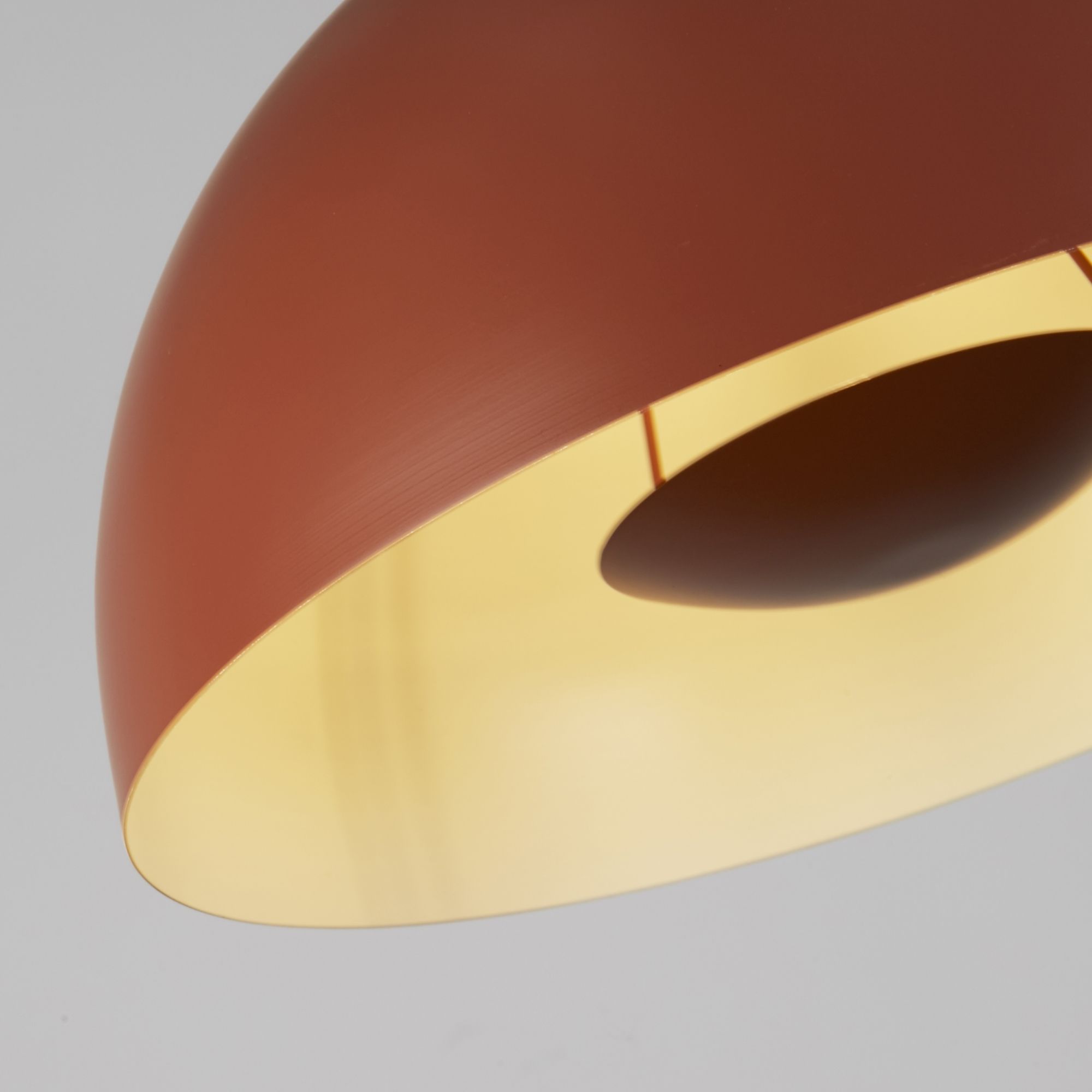 Close up of the Mars pendant's rim, showing the burnt orange exterior meeting the gold interior of the dome shade