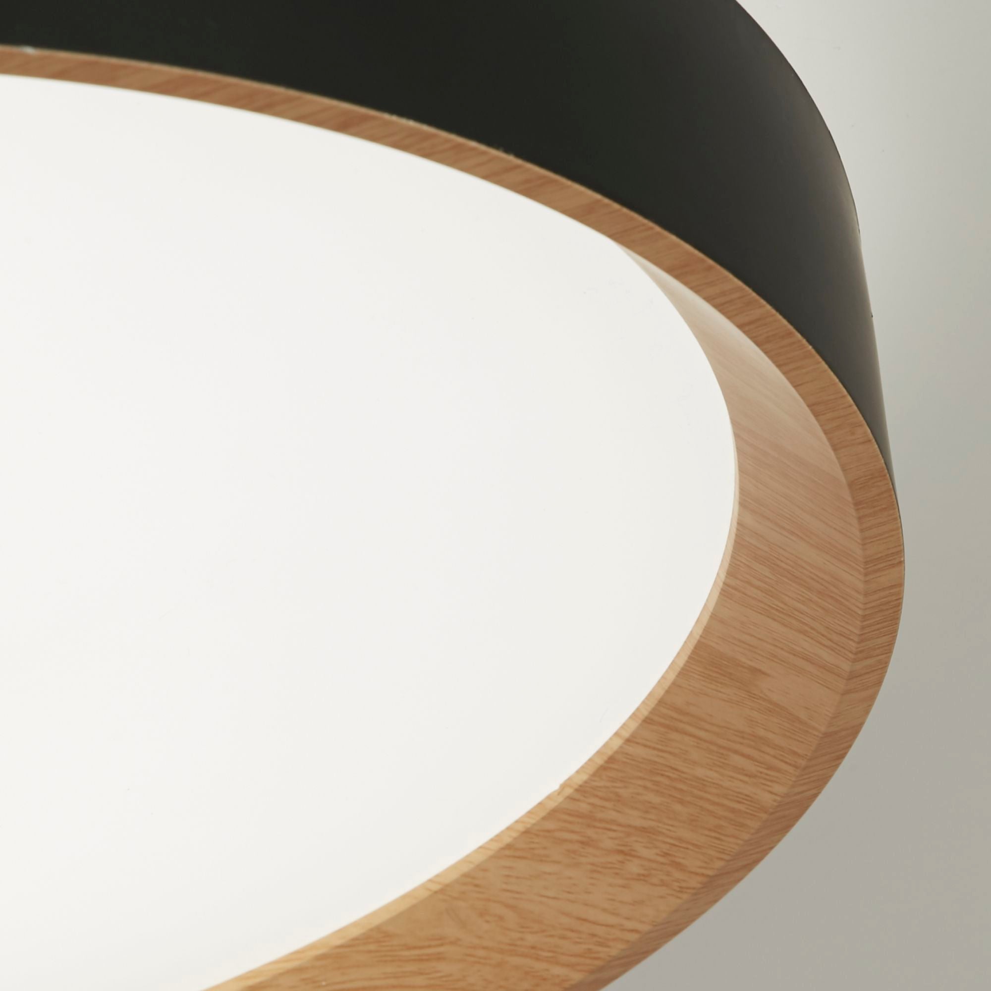 Close up of the Sorrento flush light's black rim and wood grain effect trim around the diffuser