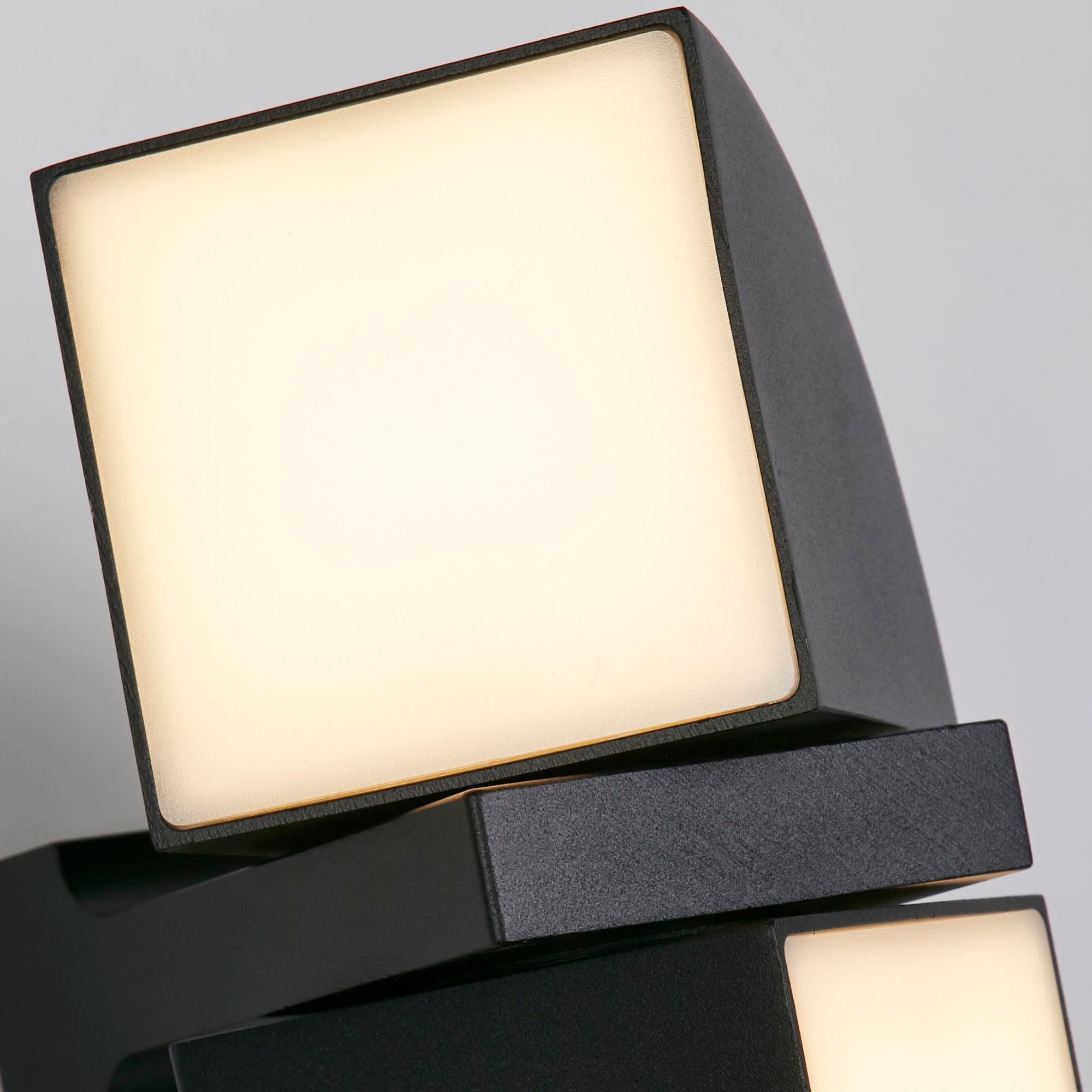Close up of the Dakota wall light's black finish and pivoting square head with frosted lens