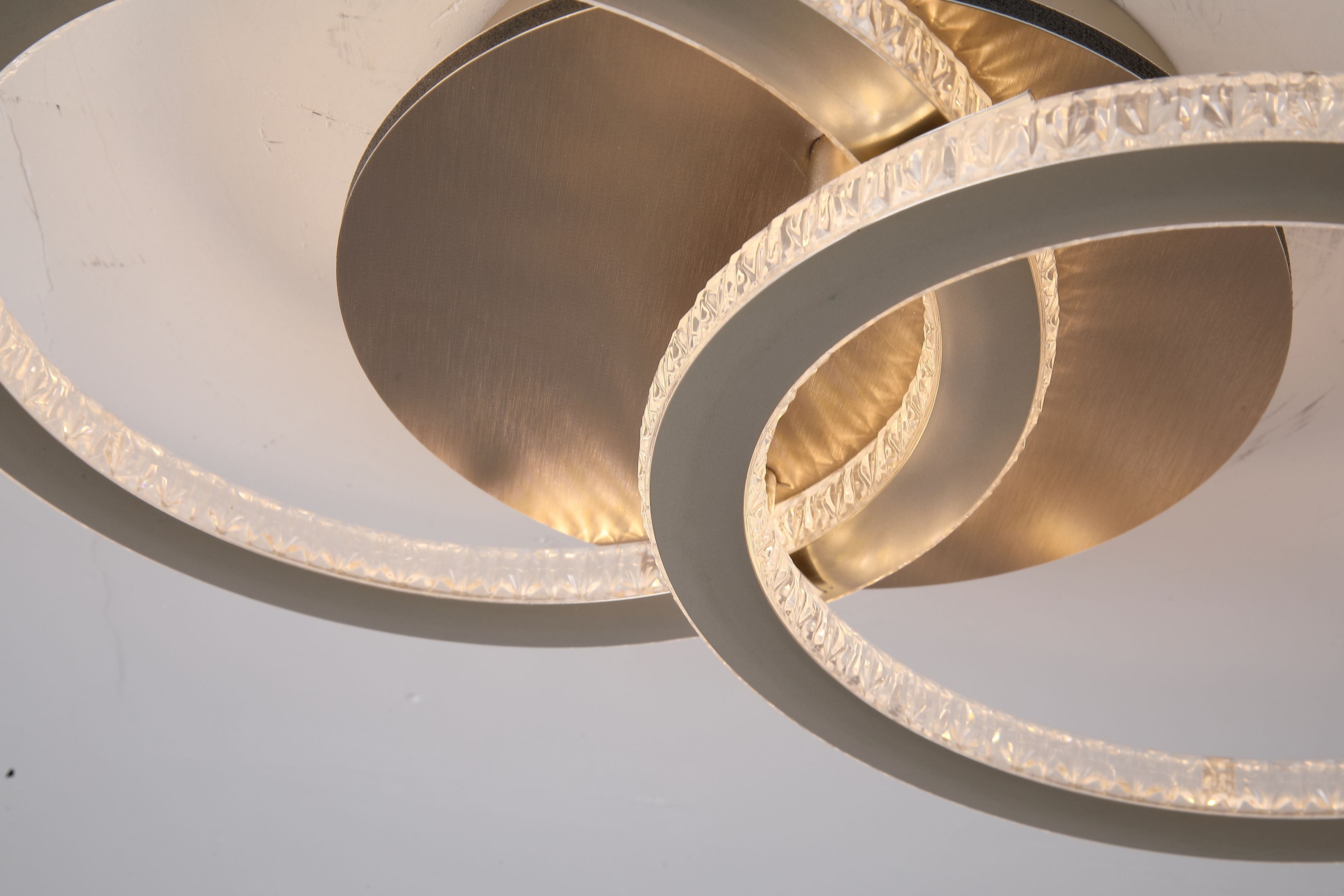 Close up detail of the Searchlight Specs LED Flush Double Ring ceiling light showing the brushed champagne metal ceiling plate and the faceted acrylic ring diffuser lit from within