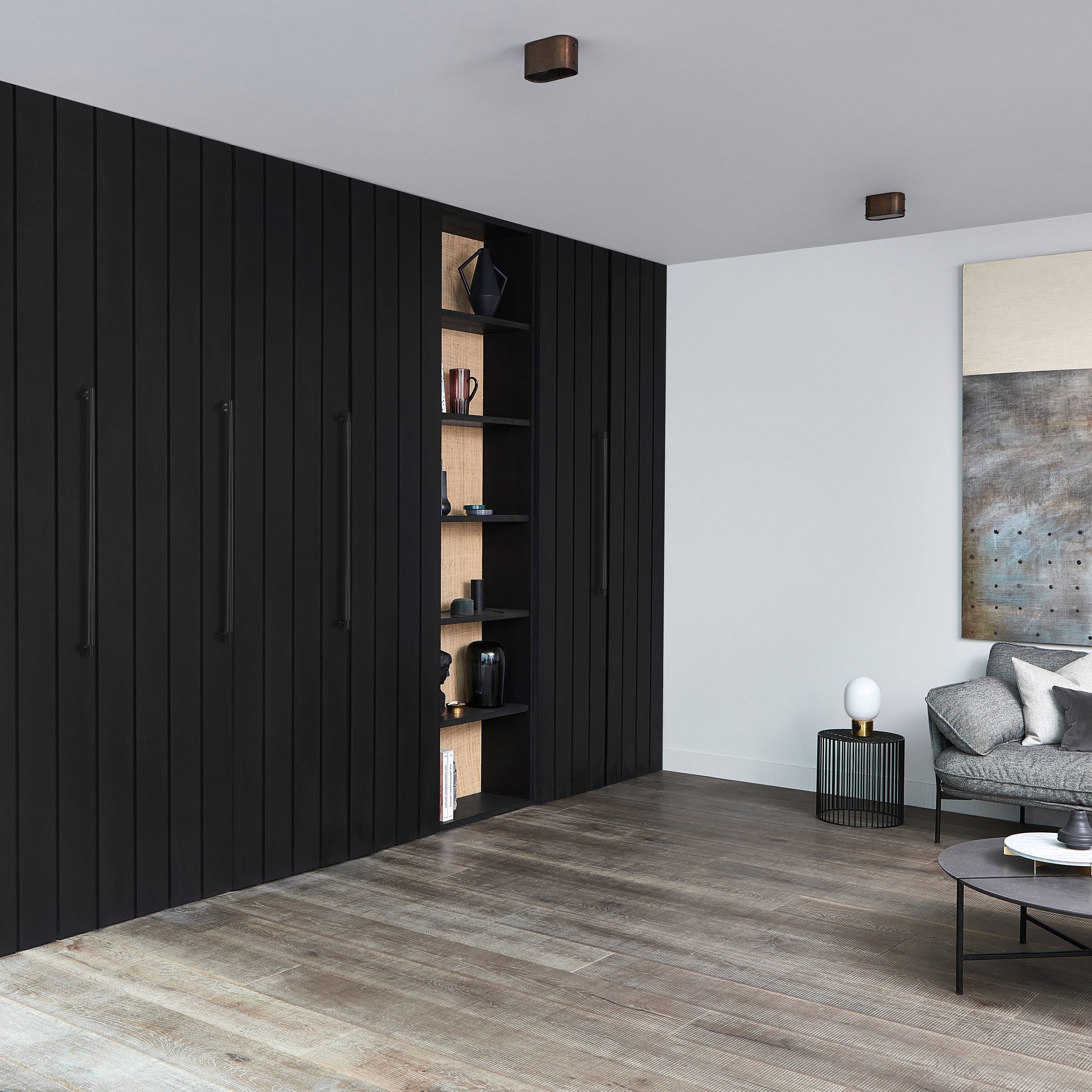 Black slatted wardrobe wall fitted with several vertical Cross Knurl pull bars