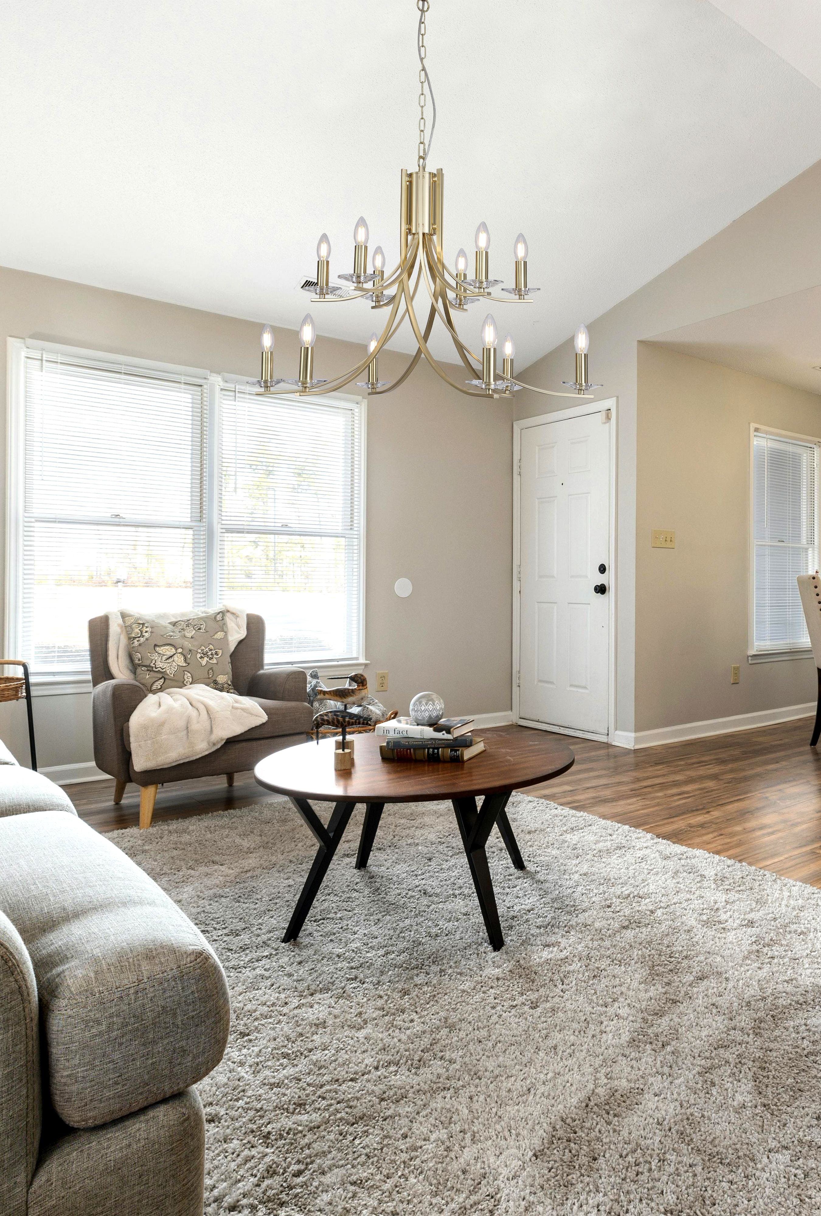 Searchlight Ascona 12 Light Pendant in satin brass styled above a round coffee table in a bright, neutral toned living room