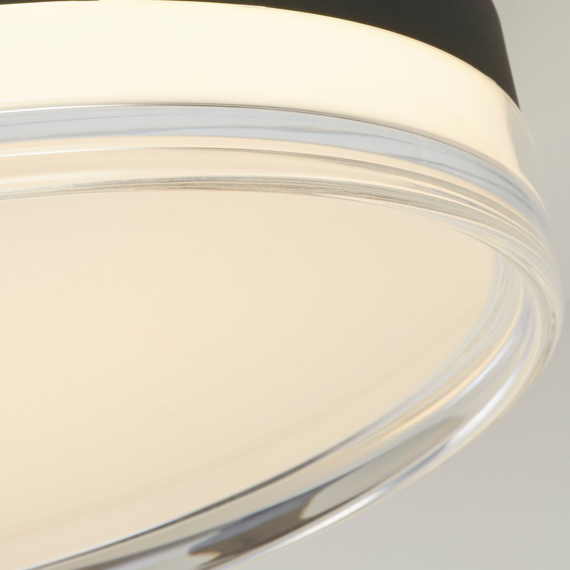 Close up of the Searchlight Cyprus's clear acrylic rim and diffuser, showing the warm glow at the shade edge