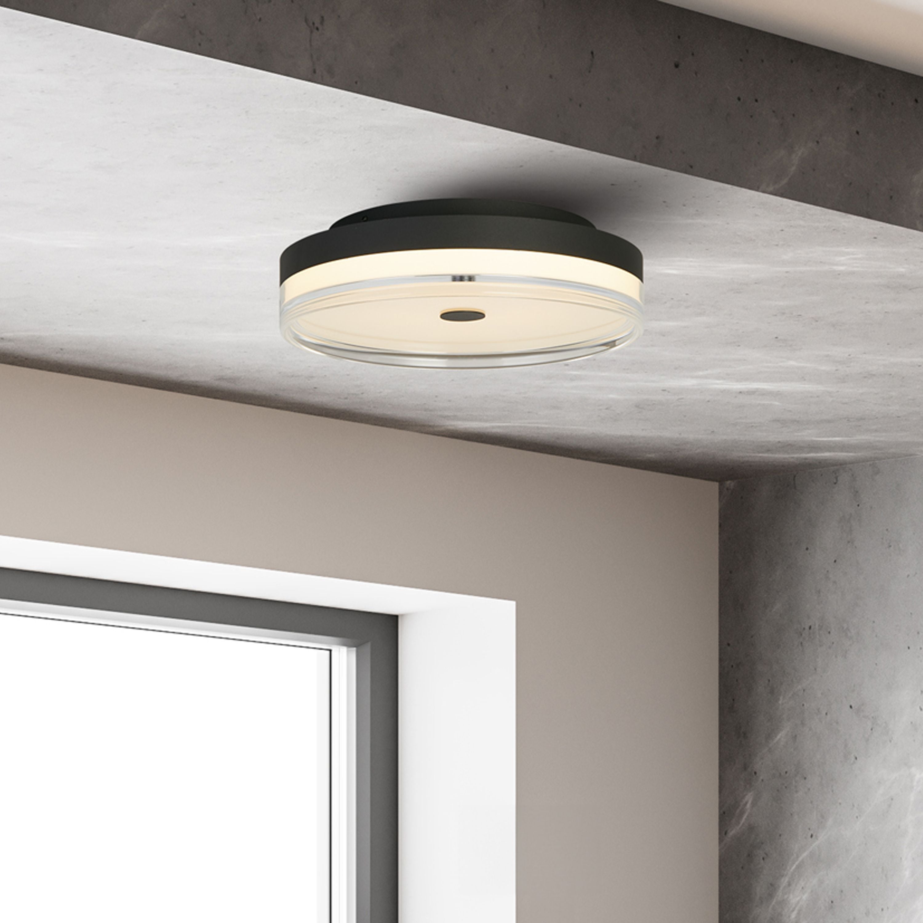 Searchlight Cyprus LED Flush 40cm in black shown lit on a concrete ceiling above a window in a minimalist styled interior