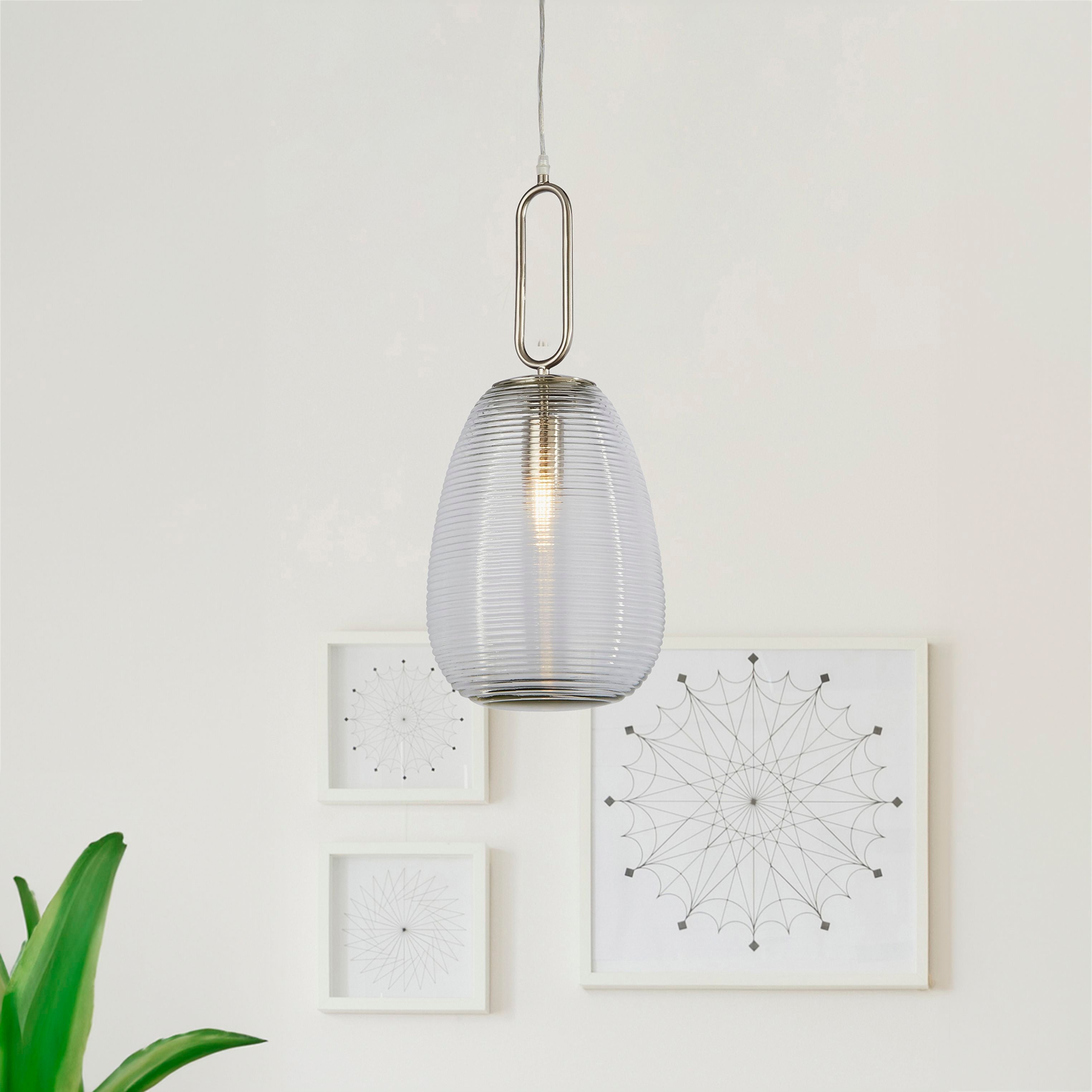 Searchlight Elixir pendant light hanging in a styled white room with framed geometric line art and a potted plant