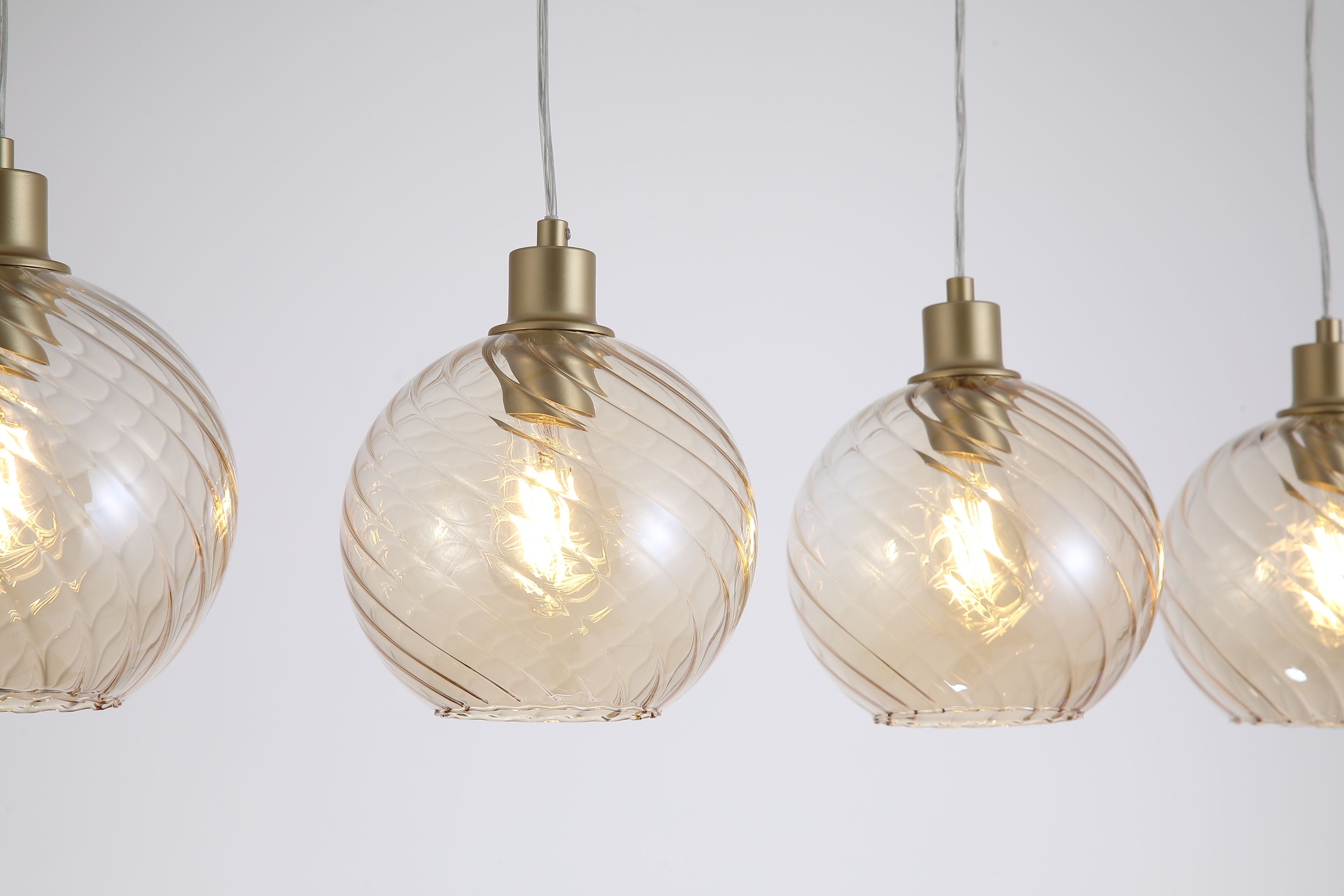 Close up of the champagne glass globe shades on the Radiance 4 Light Bar Pendant, showing the swirled texture and gold lamp holders