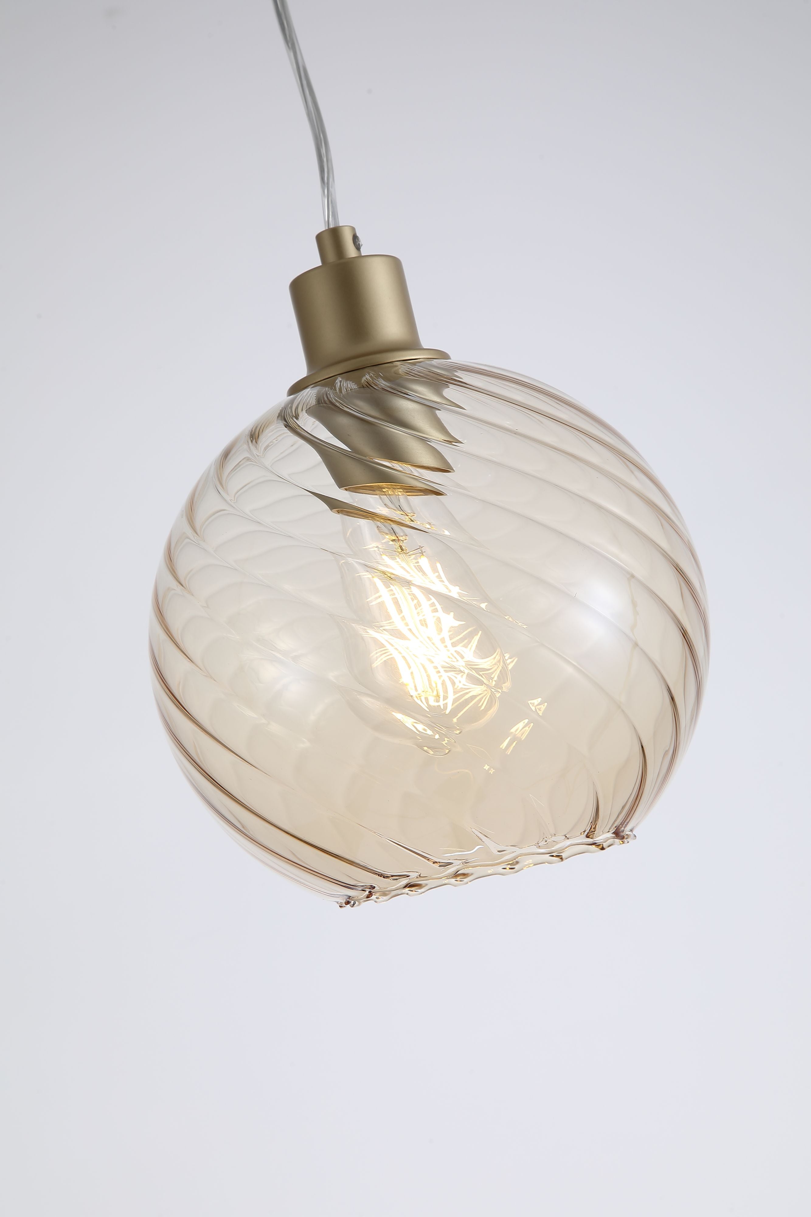 Close up of the champagne glass globe on the Radiance 1 Light Pendant, showing the swirled texture and gold lamp holder with the bulb lit