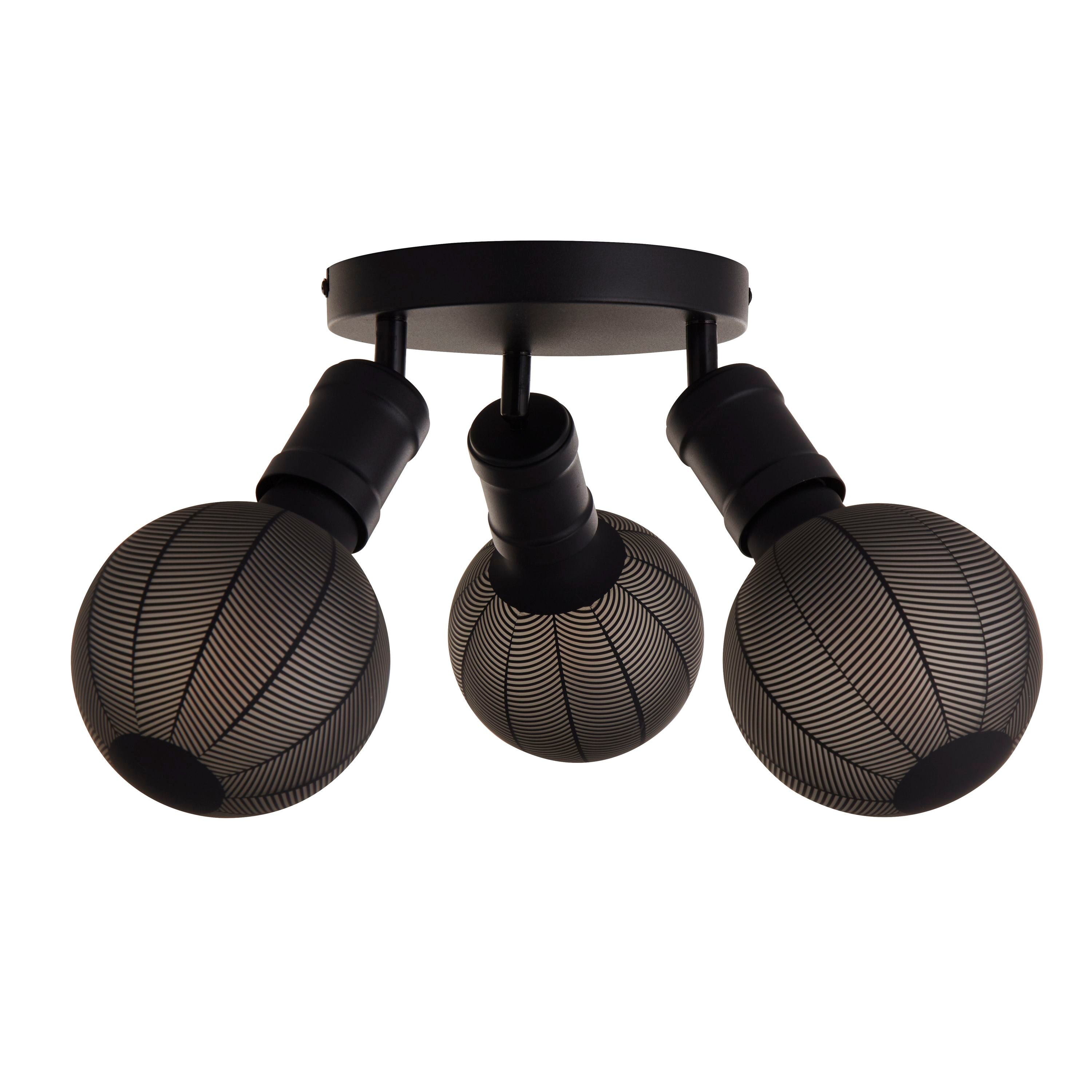 Ceiling light fitted with three round glass shades featuring a linear leaf pattern in black and white, mounted on a black ceiling plate