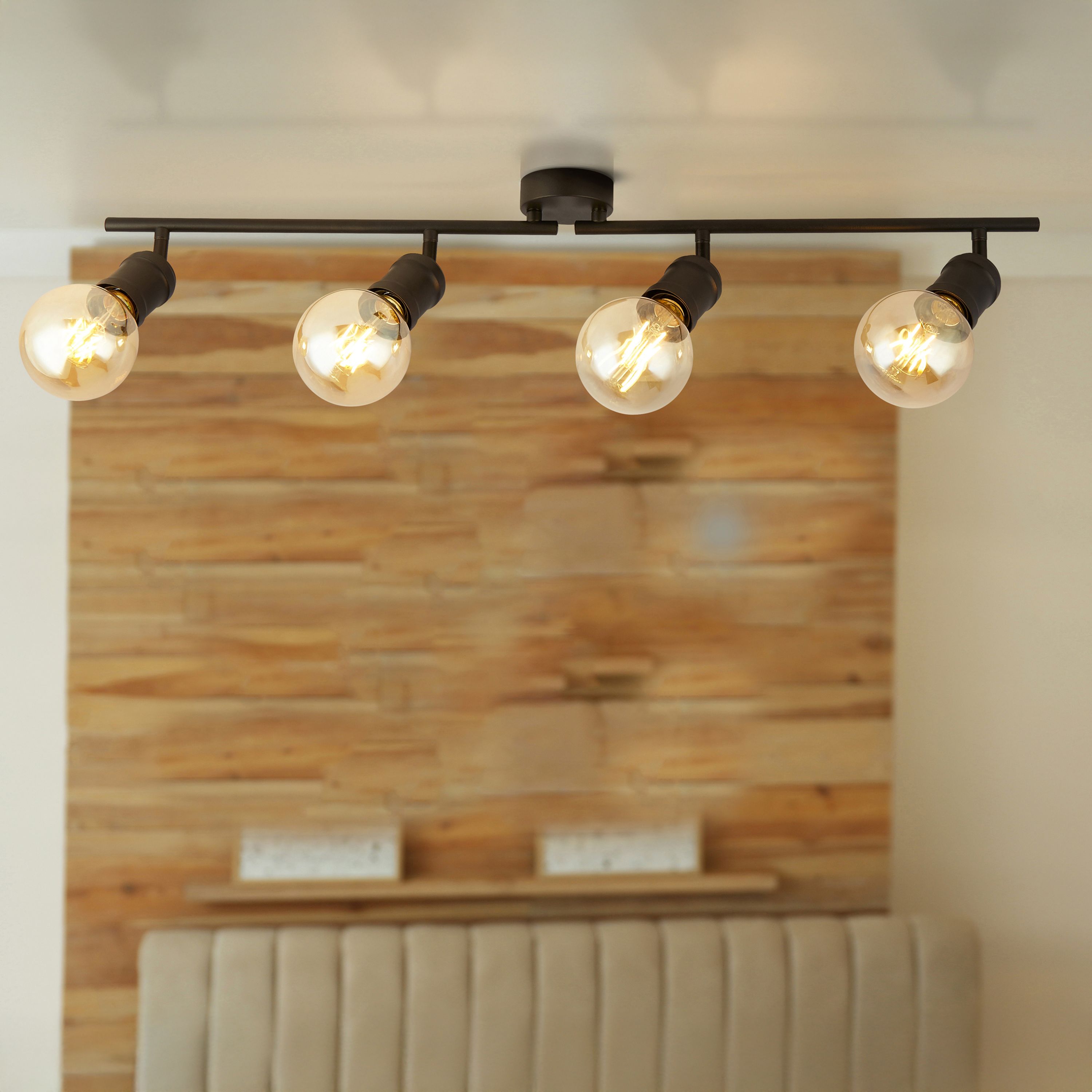 Searchlight Dance 4 light split bar spotlight styled above a reclaimed wood feature wall and beige upholstered headboard, all four bulbs lit