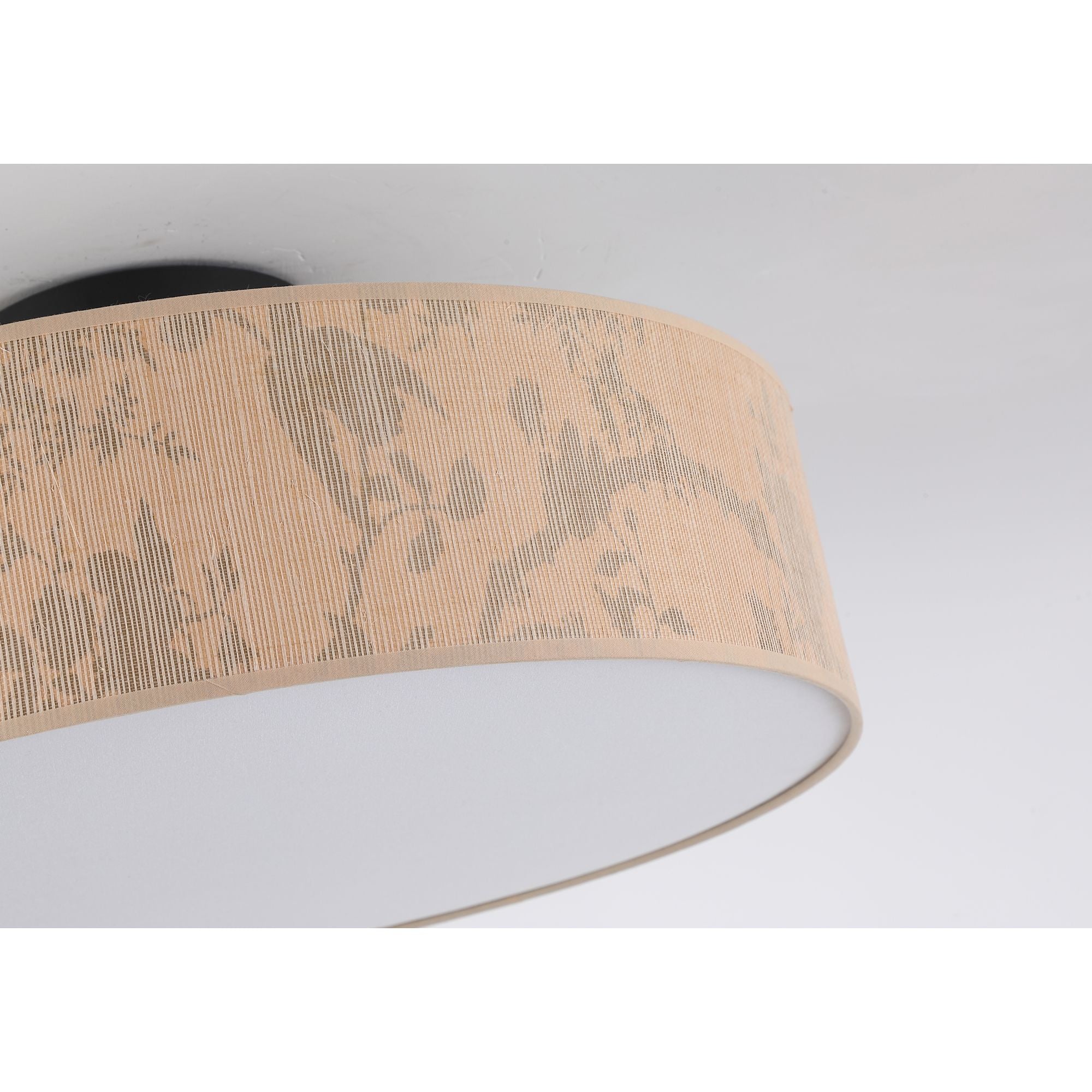 Close up of the Isla flush ceiling light's shade fabric, showing the woven leaf print texture and stitched edge trim