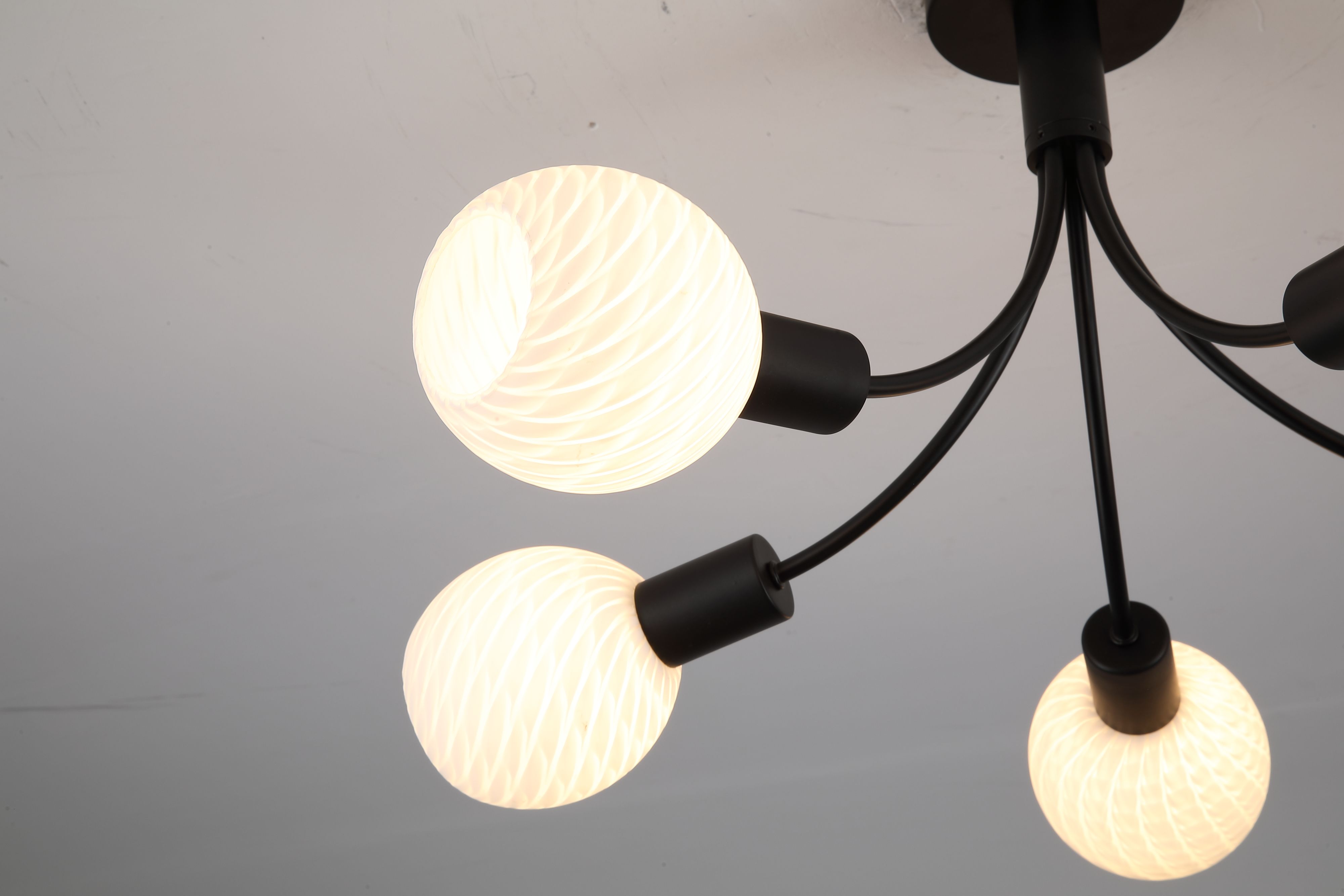 Close up of two frosted, spiral textured glass shades on the Nova ceiling lamp, showing the ribbed glass detail