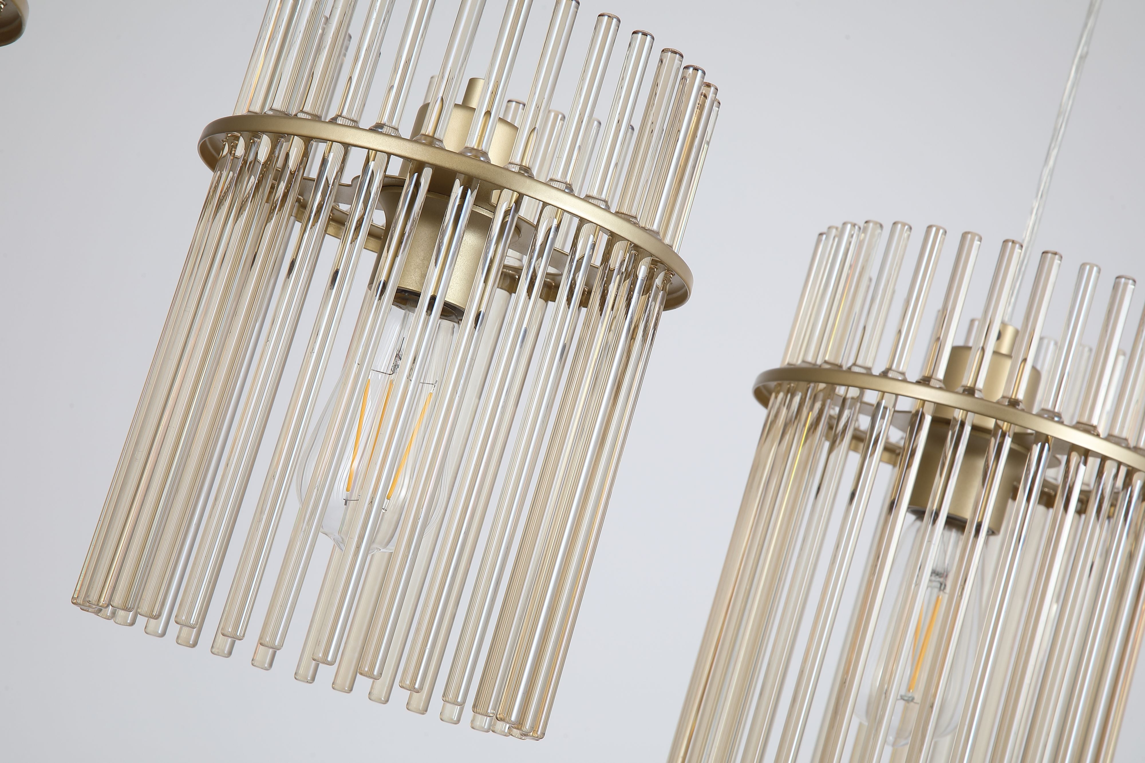 Close up of two Swizzle bar pendant shades, champagne glass rods, gold mounting rings and lit E27 bulbs