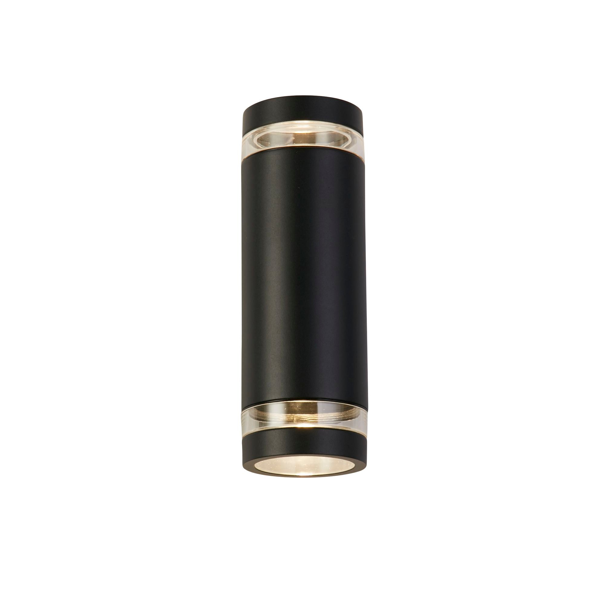 Searchlight Austin black cylindrical outdoor wall light on a white background, showing the clear lens rings at the top and bottom glowing softly