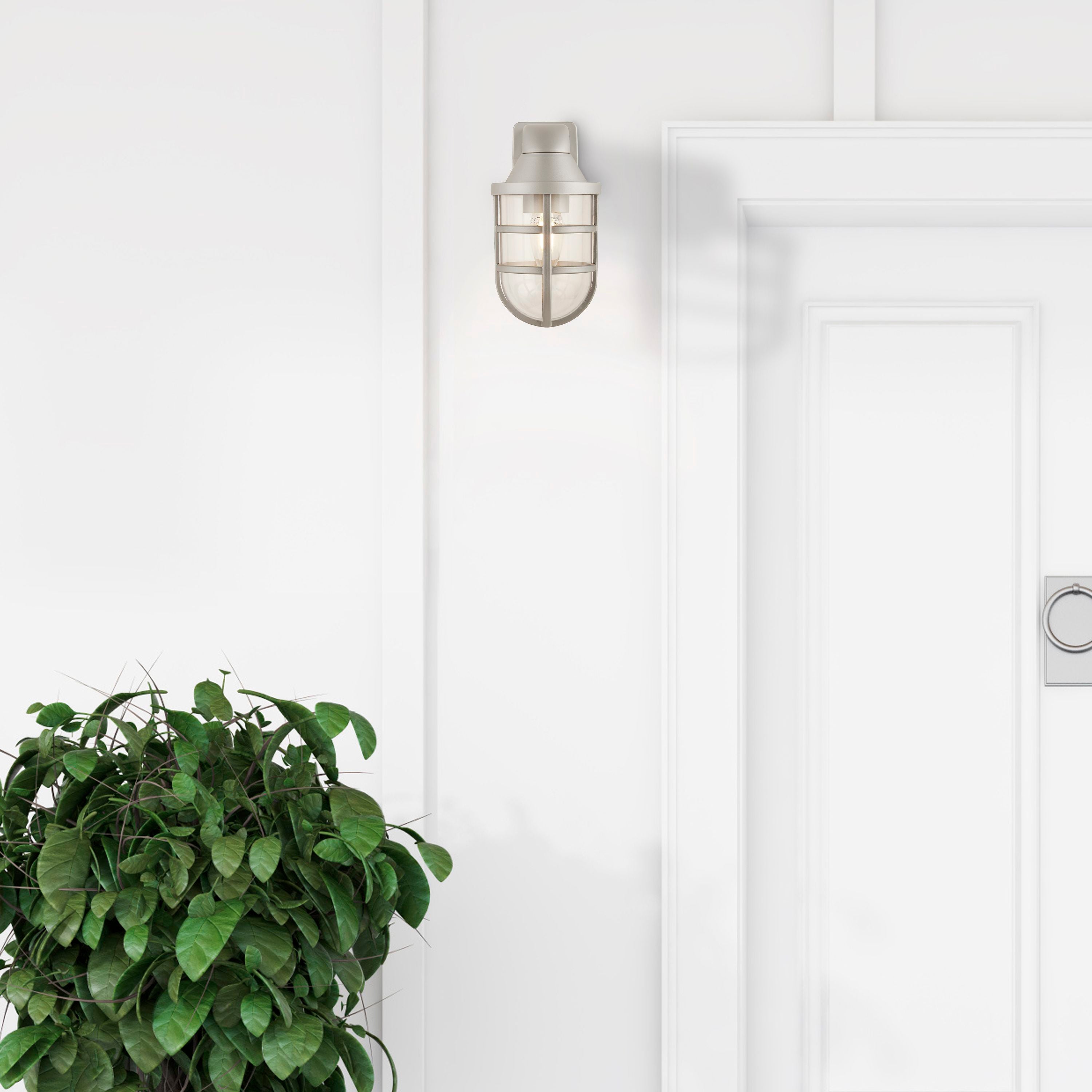 Searchlight Seaside silver ships lantern wall light mounted beside a white panelled front door, with a leafy plant in the foreground