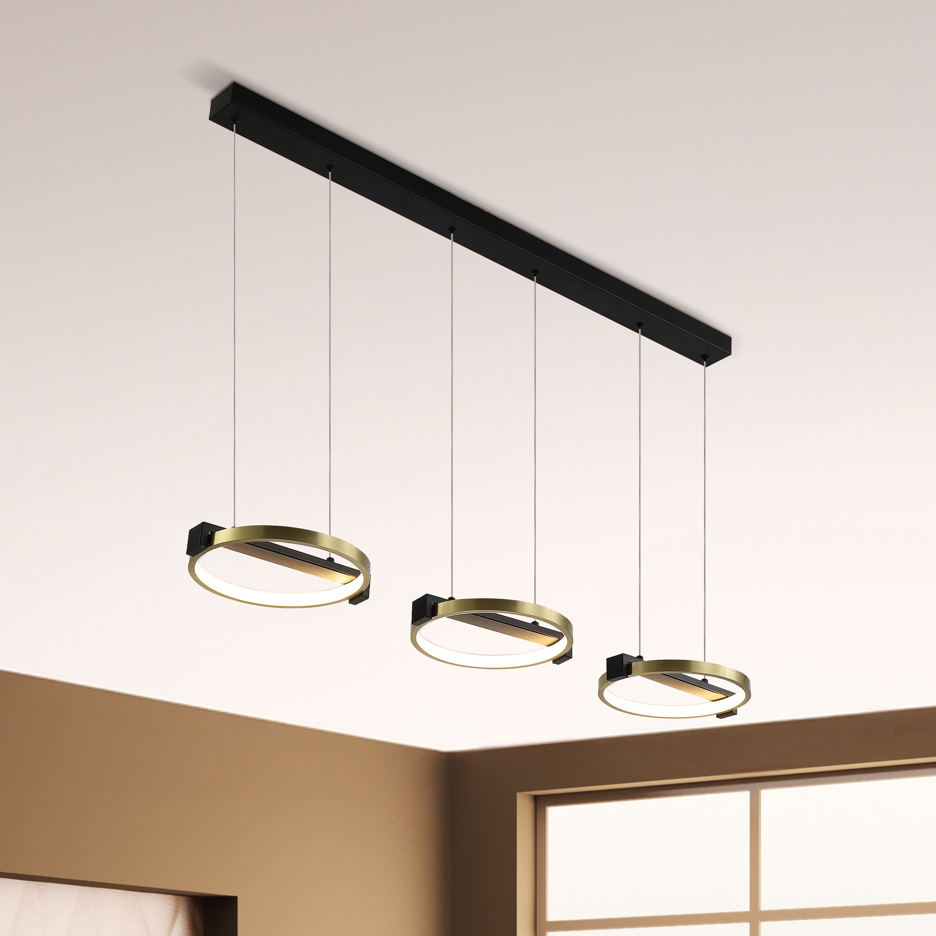 Searchlight Aerial 3 Light LED Bar Pendant installed in a room corner with a shoji style window, three gold and black rings glowing warm white