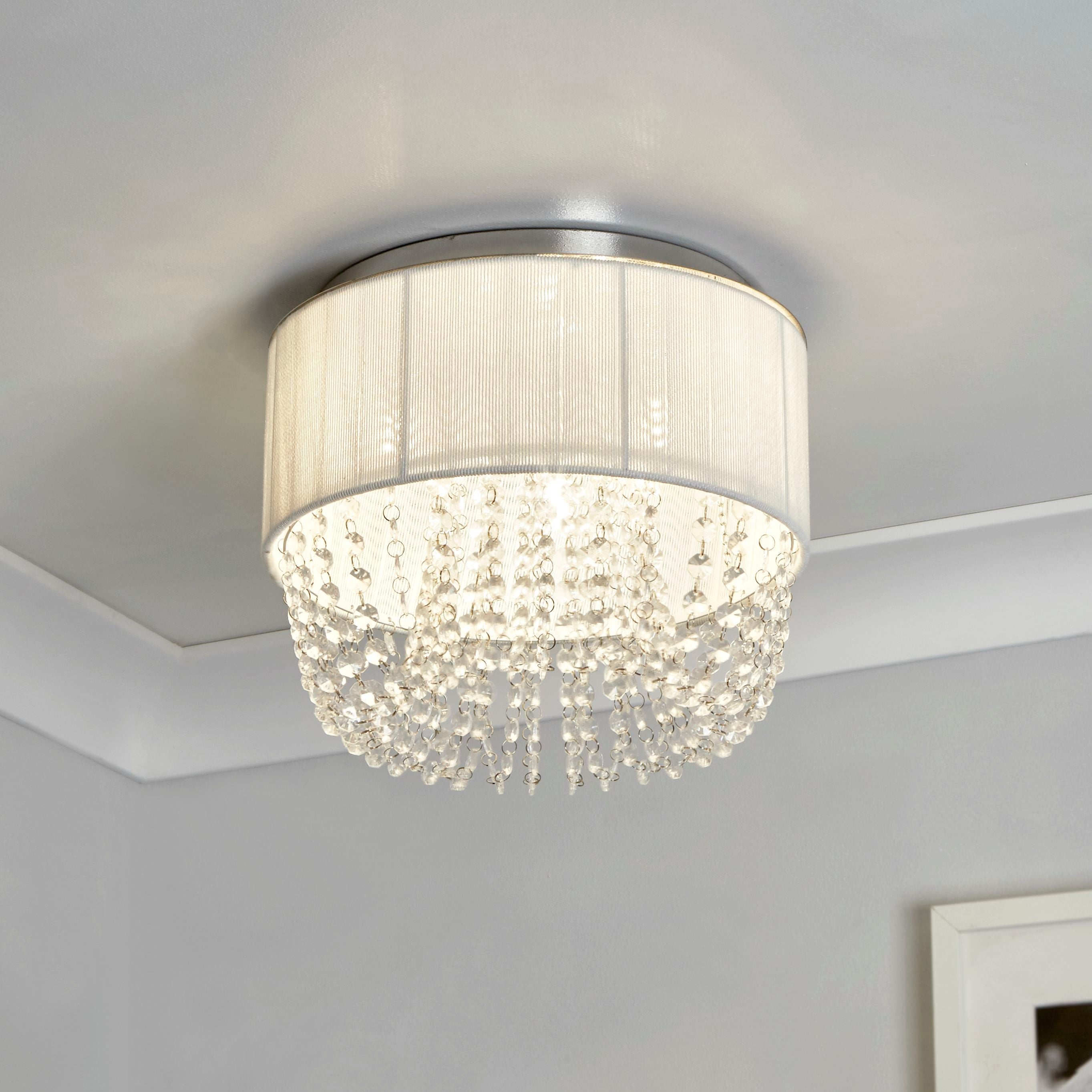 Searchlight Bellano 3 light flush ceiling light fitted to a bedroom corner ceiling above a potted palm