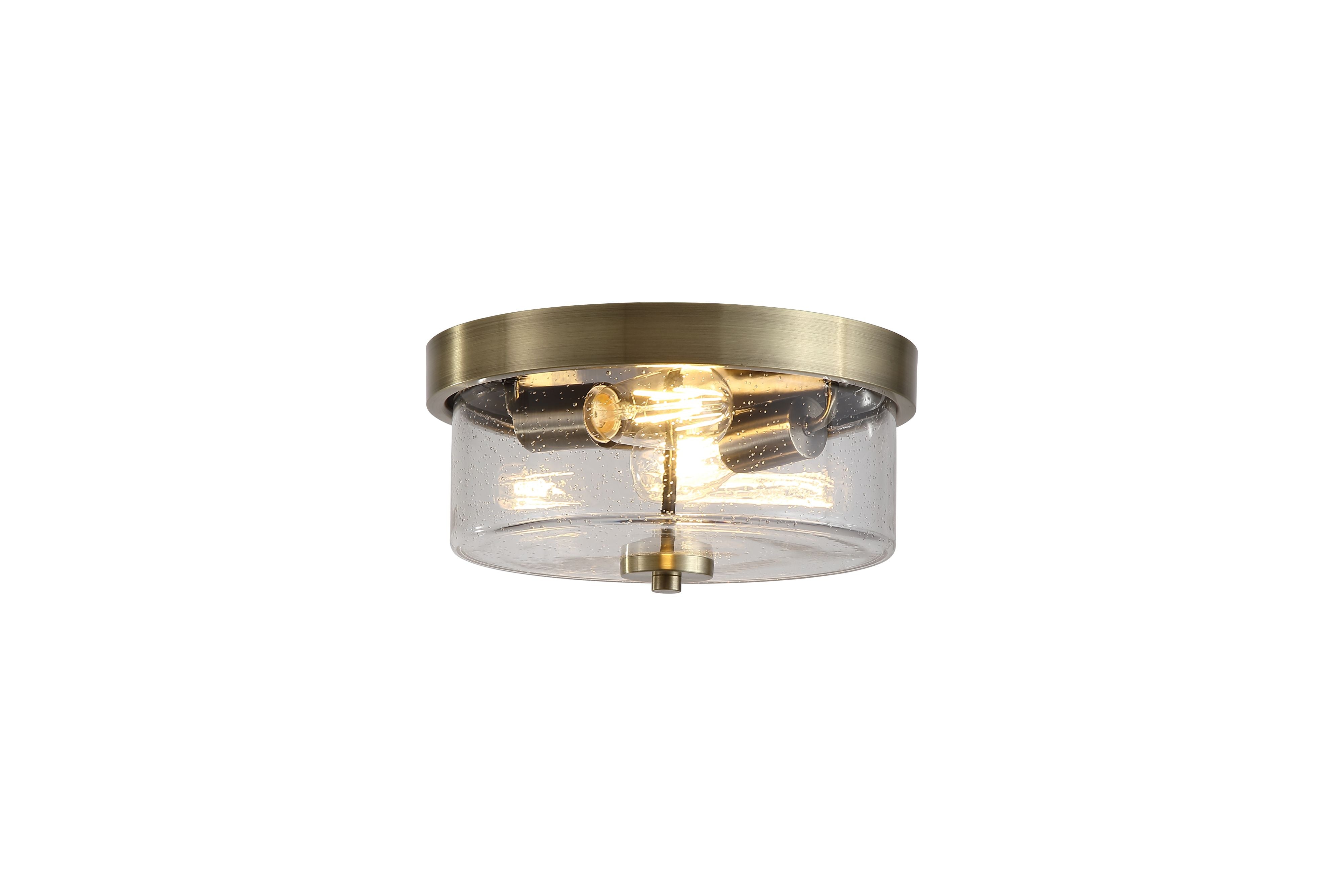Searchlight Preston 2 light flush ceiling light in antique brass, studio shot with the seeded glass drum lit and bulbs visible
