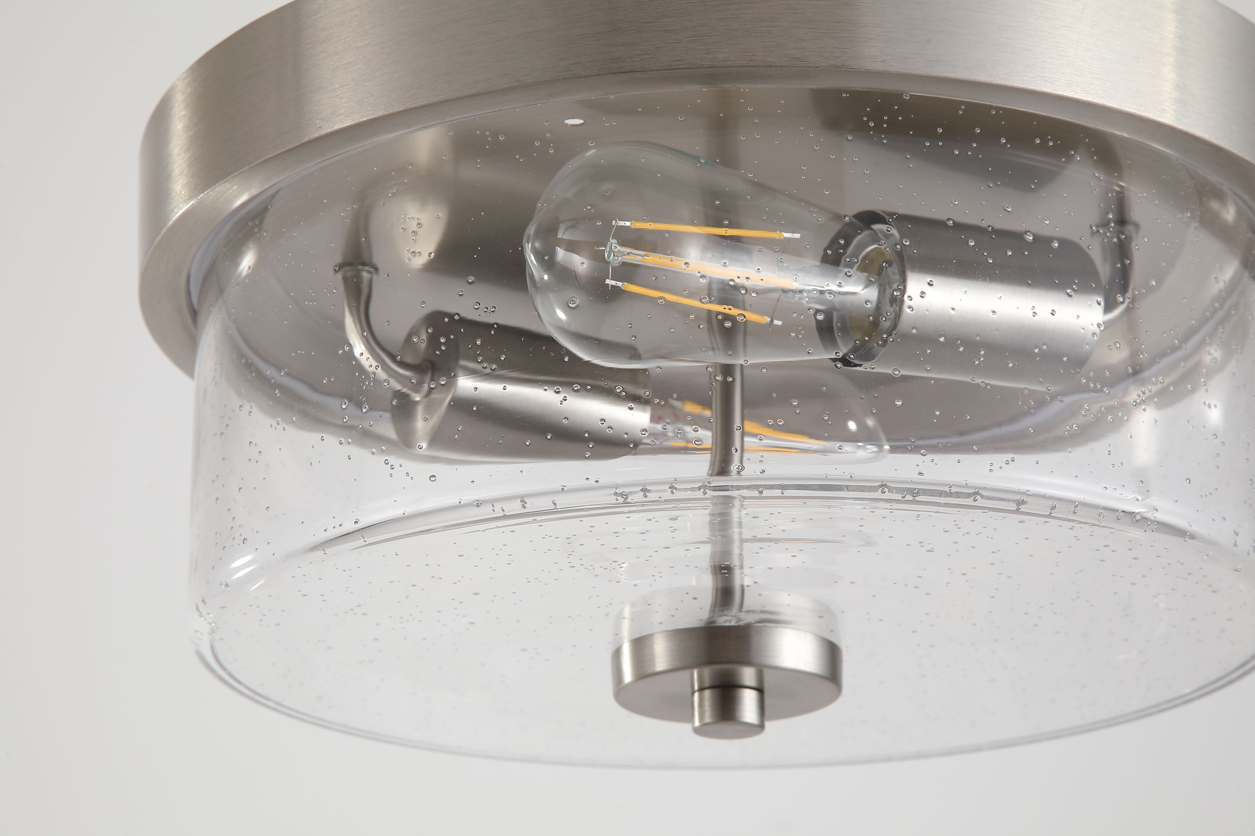 Close up of the Searchlight Preston's satin silver fitting and filament bulb through the seeded glass drum