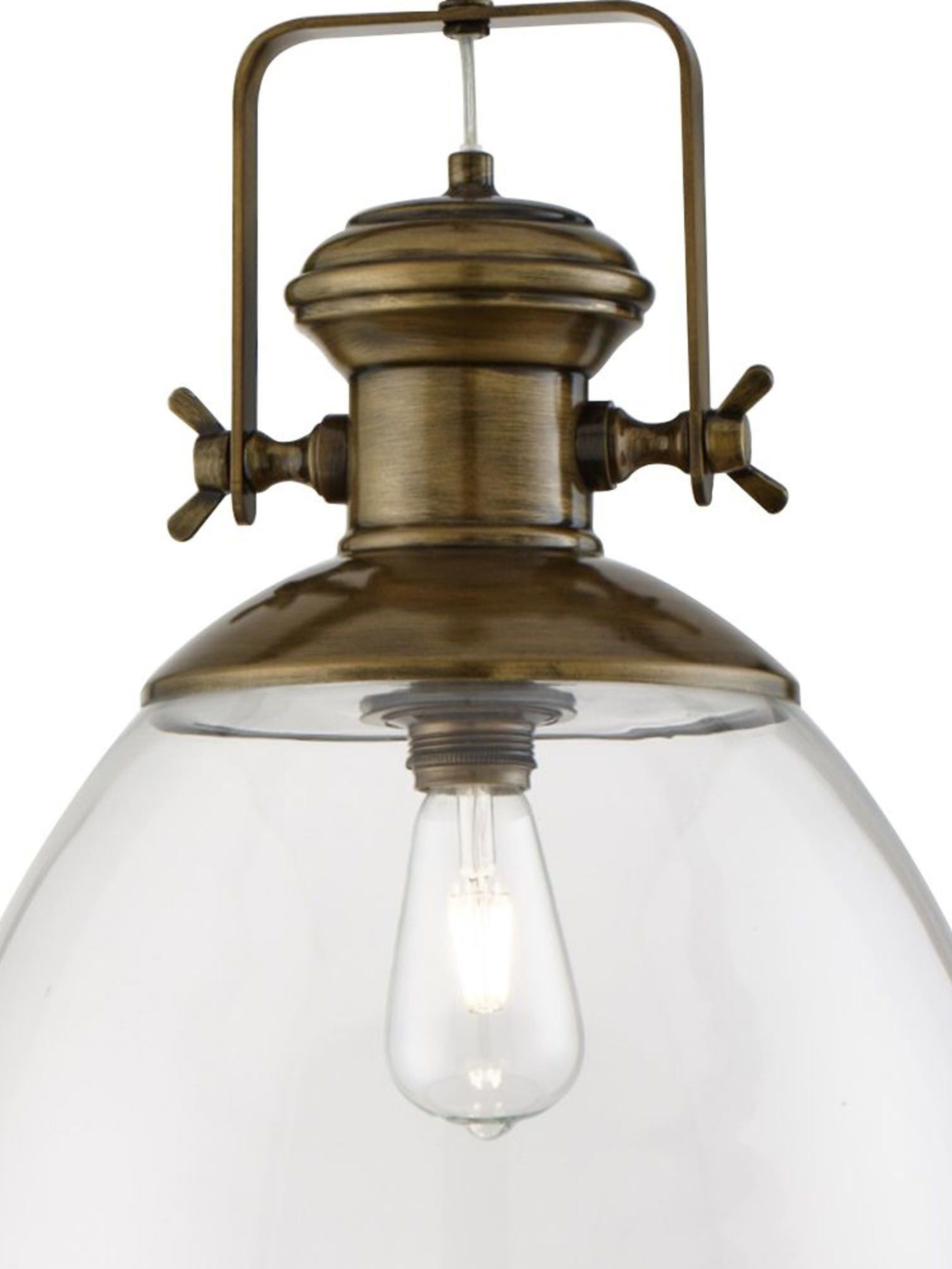 Close up of the Industrial pendant's antique brass gallery, cross headed screws and filament style bulb