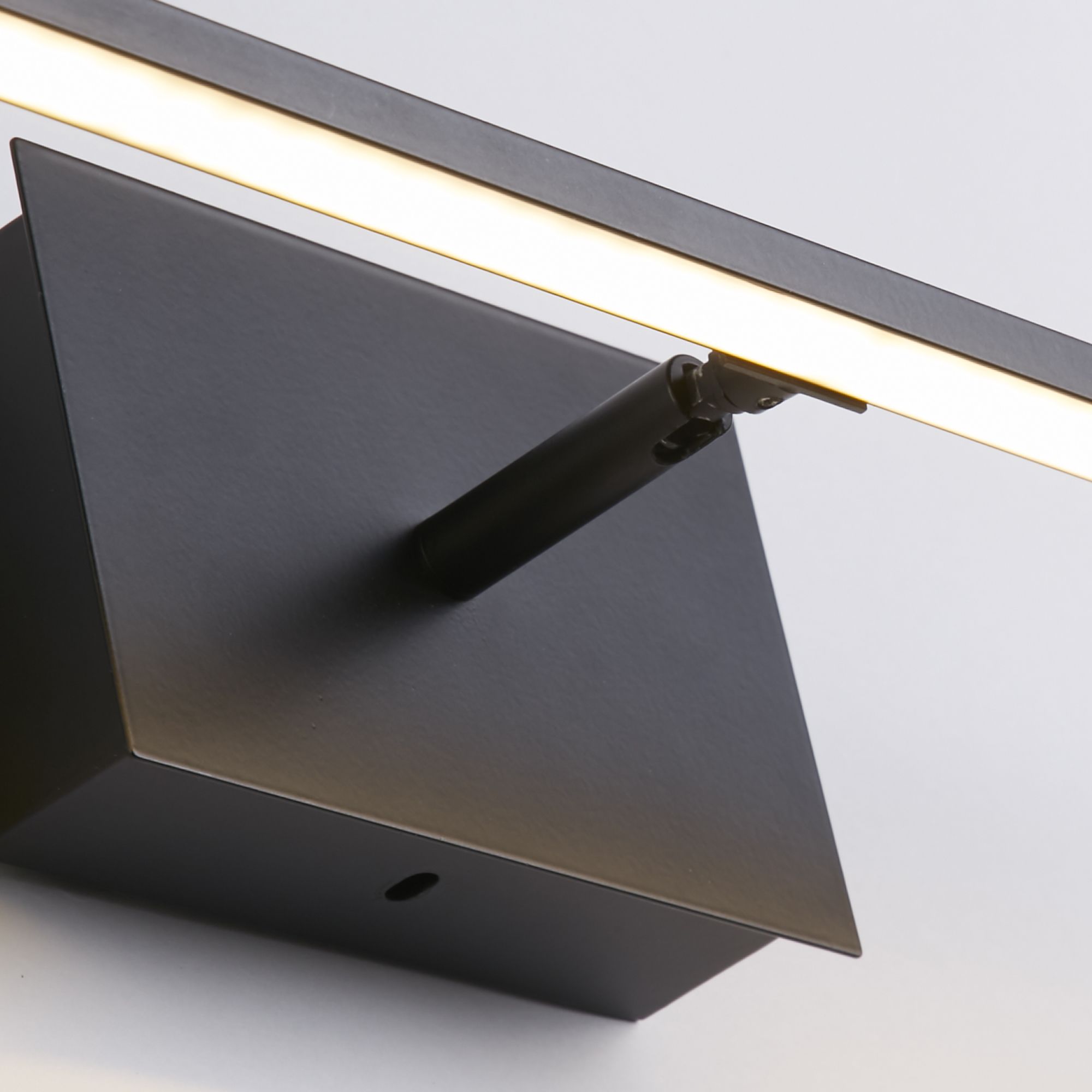 Close up of the matt black Amalfi wall light showing the swivel spotlight beneath the bar and the small pinhole switch on the backplate