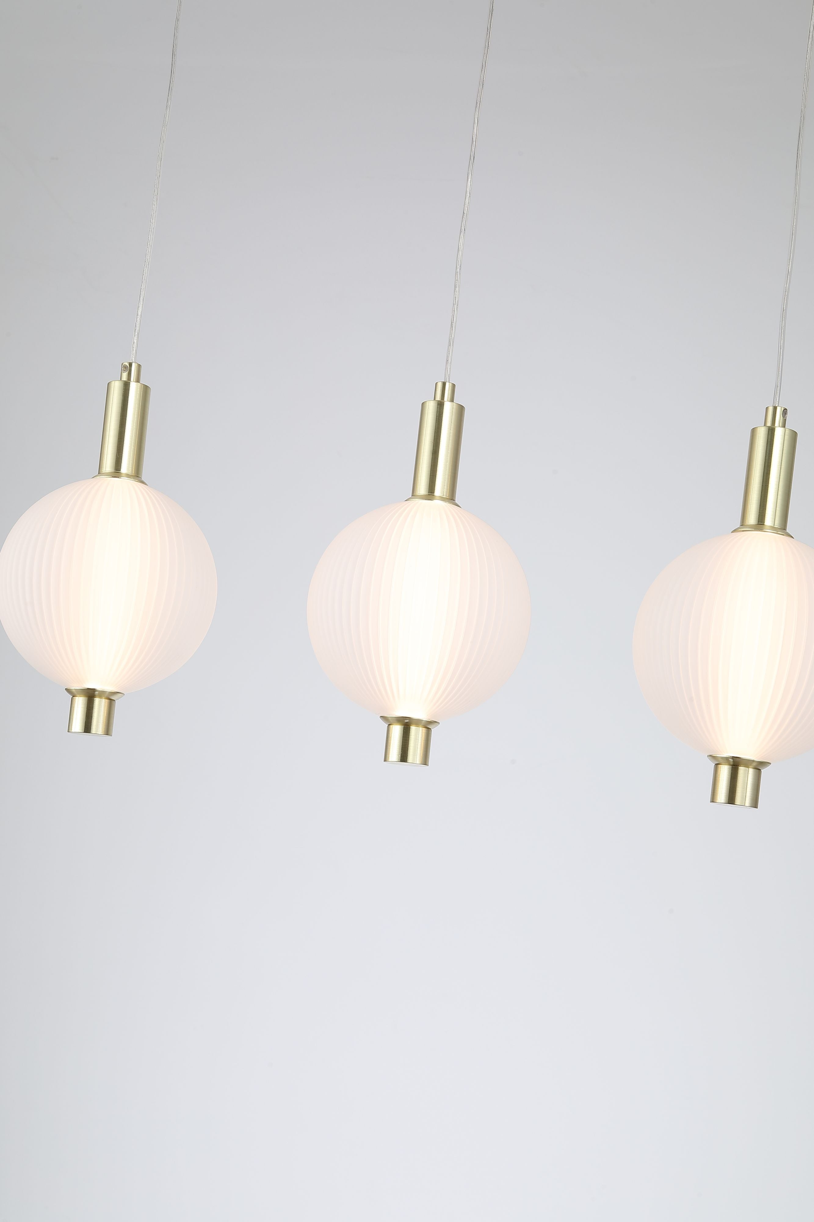 Searchlight Luminique LED 4 light bar pendant in satin brass, close up of the ribbed opal glass globes and satin brass fittings