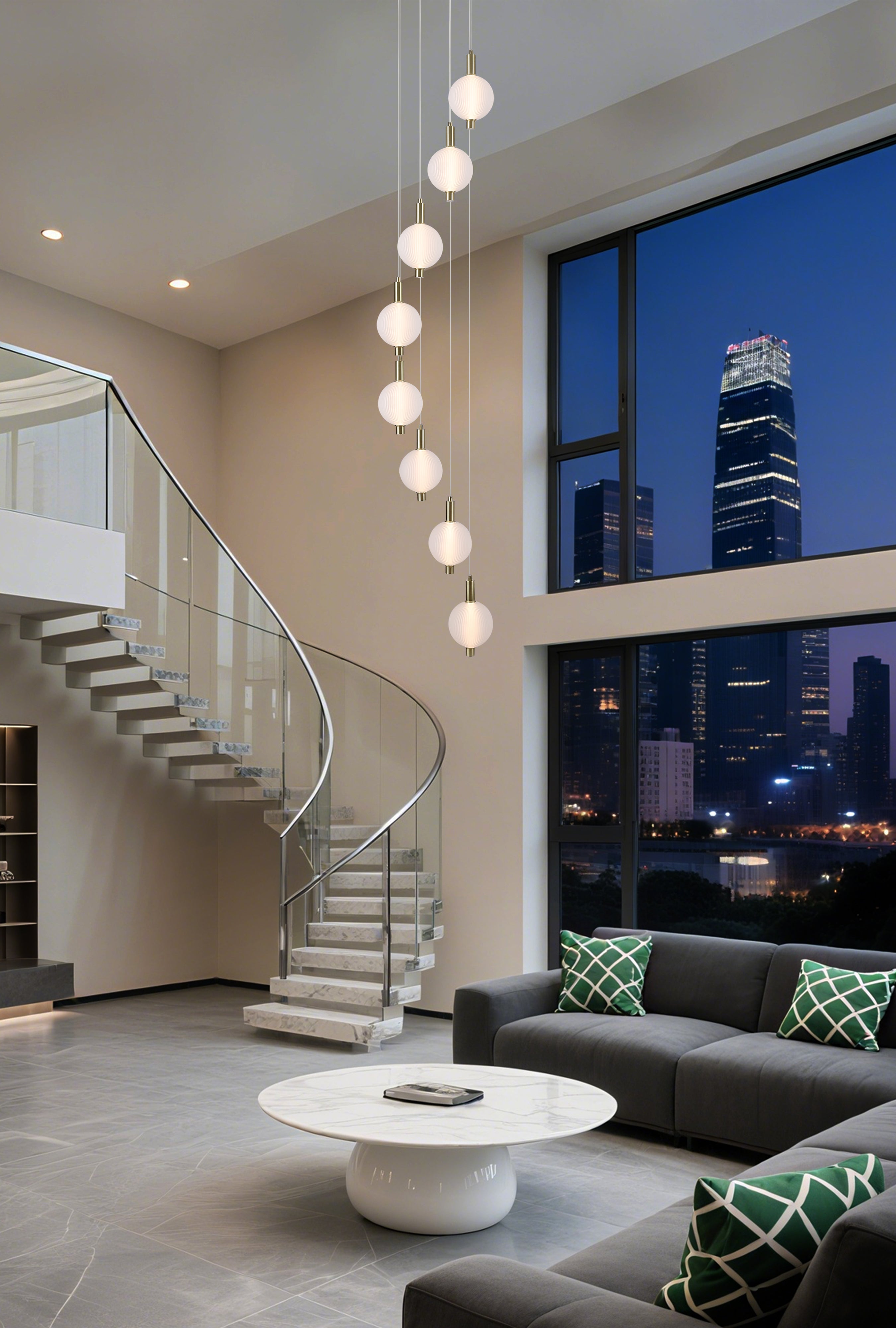 Searchlight Luminique LED 8 Light Pendant in satin brass hanging above a spiral staircase in a double height living room at night, city skyline visible through the window