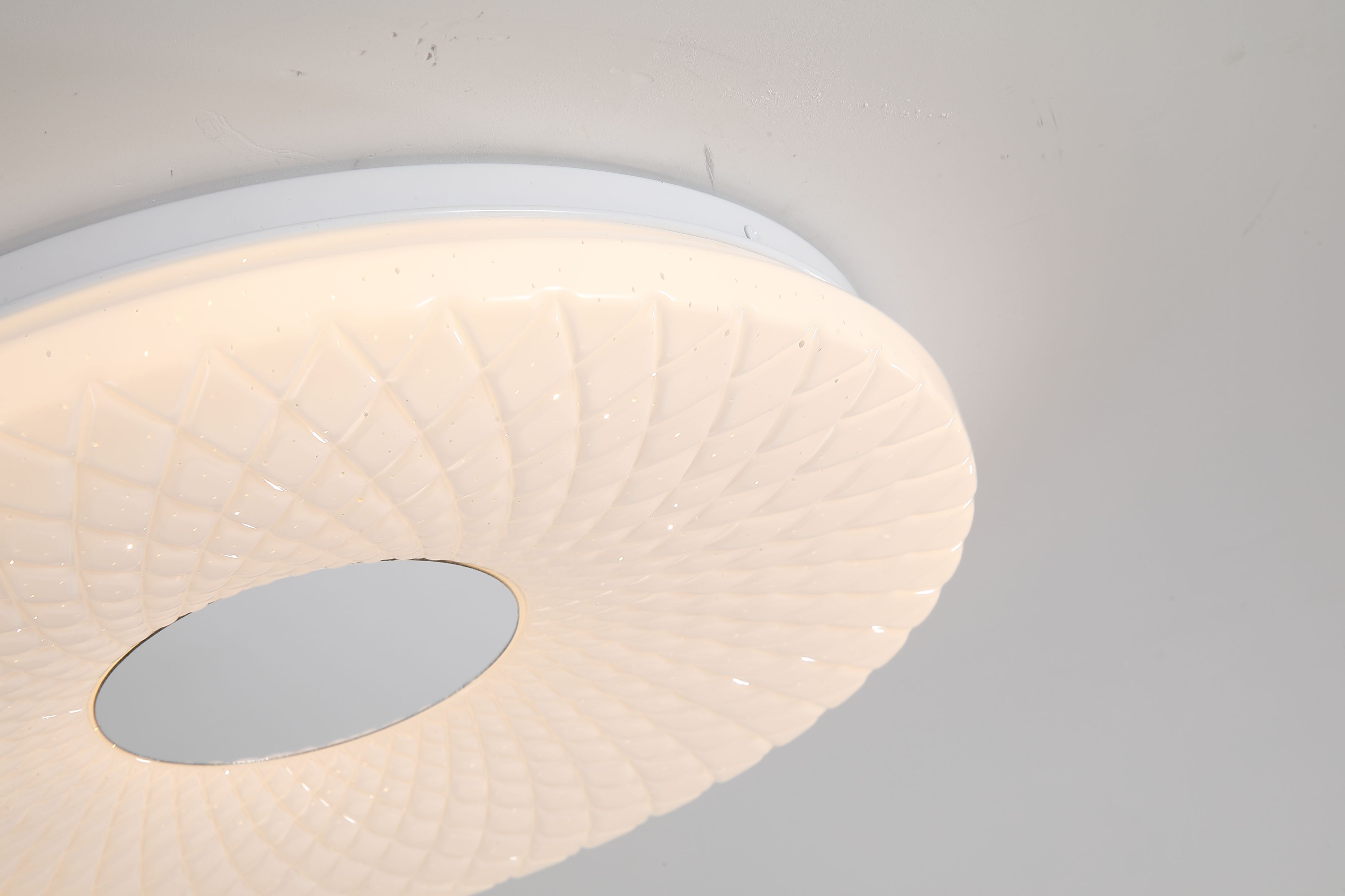 Close up of the Halolux flush ceiling light fitted to a ceiling, showing the diamond textured acrylic diffuser and central white cap