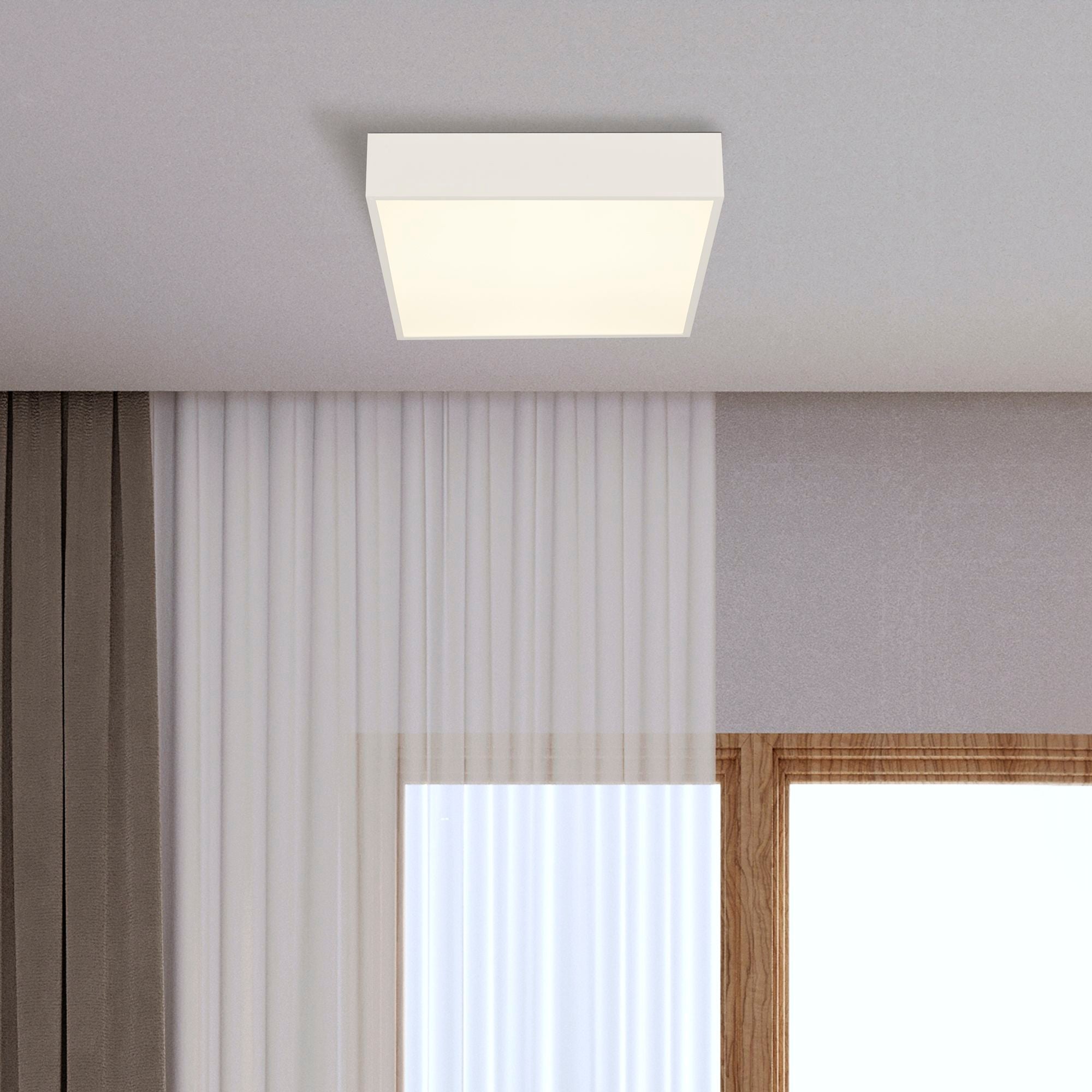 Searchlight Zeus flush ceiling light mounted on a ceiling above sheer curtains and a wood framed window, lit